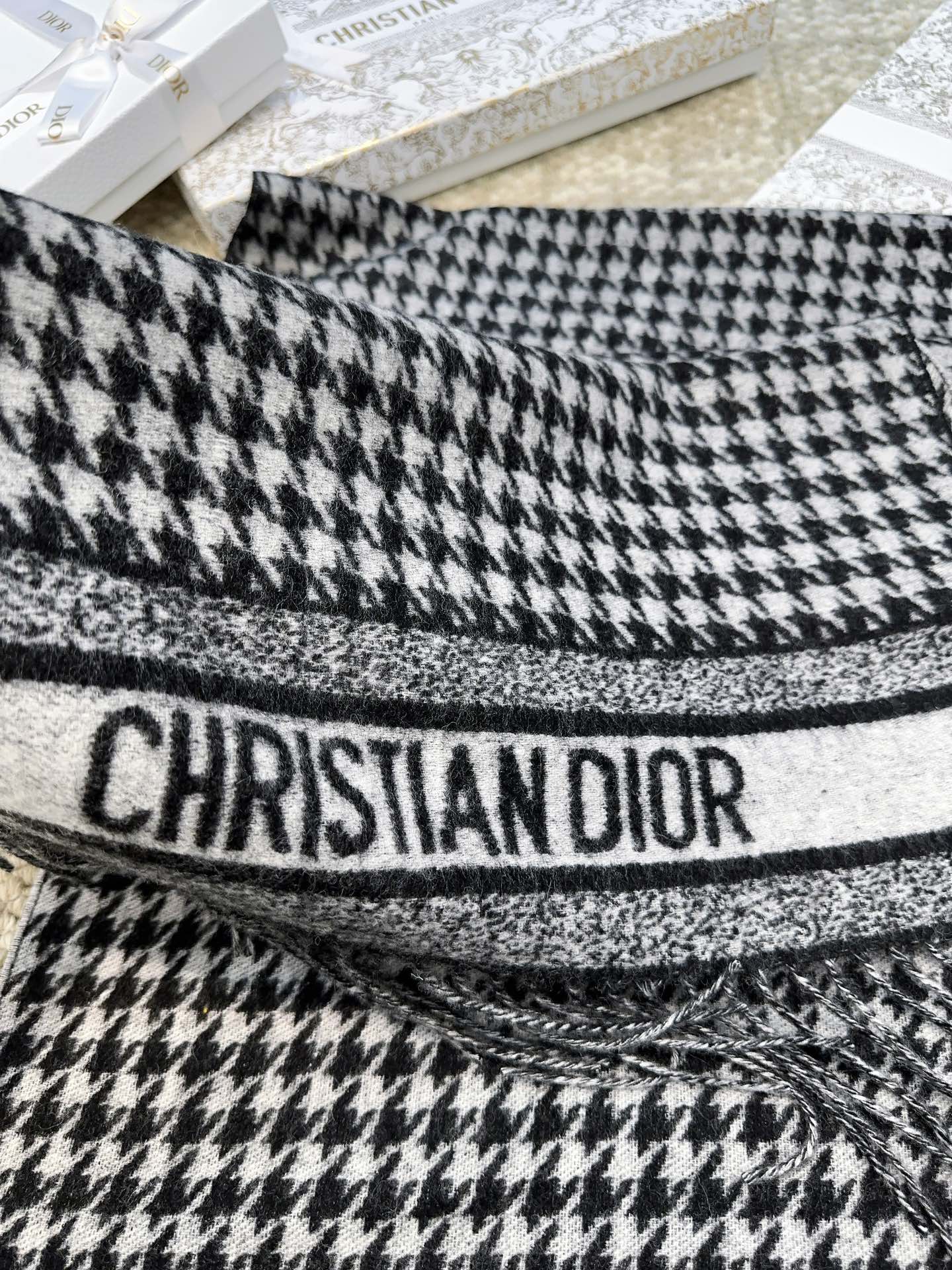 Dior24年新款千鸟格围巾这款围巾向经典的粉色和白色千鸟格纹图案致敬采用羊绒面料精心制作双面设计饰以流