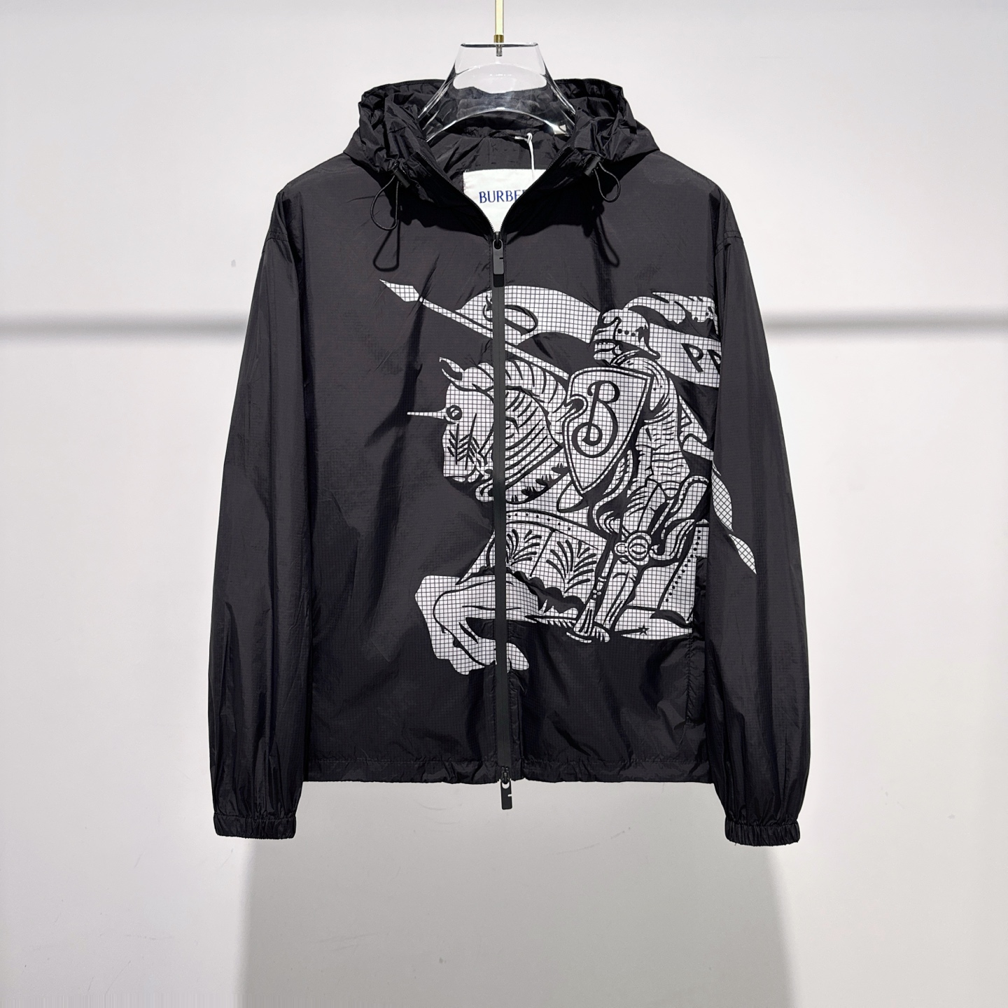 NO:502021,Burber Equestrian Knight Logo Shock Jacket Jacket The fabric is made of high-quality nylon fabric, with lightness, LL1670350 wear resistance, windproof and waterproof, which is very suitable for making casual jackets. In the fabric treatment, special waterproof coating treatment technology is used to enhance its waterproof performance. Cut and sew the fabric into the required shape and size according to the design drawings. Use advanced sewing equipment and technology to sew the fabric together to form the overall structure of the jacket. During the sewing process, special attention should be paid to the details, such as sewing of zippers, pockets, cuffs, etc., to ensure its firmness and aesthetics. A very accurate restoration of the logo pattern is required. Logo and printing treatment Decorate the Equestrian Knight logo (EKD) and B-shaped zipper heads on the jacket through glue printing to highlight the brand characteristics.  Printing treatment uses environmentally friendly and washable pigments to ensure that the printing is long-lasting and bright. Drawstring hood and hem design can adjust the tightness according to weather changes to provide better protection. Back-fitting and inspection The sewn jacket is processed afterwards, such as ironing, thread removal, etc., to make it more flat and beautiful. Strict quality inspection SIZE:S-XL,,burberry, jackets & coats,jackets & coats,hats,alexander wang19860909Burber马术骑士徽标 冲锋衣夹克外套 面料由高品质的尼龙面料,具有轻盈、LL1670350耐磨、防风防水等特性,非常适合制作休闲夹克. 在面料处理上,采用特殊的防水涂层处理技术,以增强其防水性能. 裁剪与缝制 根据设计图纸,将面料裁剪成所需形状和尺寸. 使用先进的缝制设备和技术,将面料缝制在一起,形成夹克的整体结构. 在缝制过程中,特别注意细节处理,如拉链、口袋、袖口等部位的缝制,确保其牢固度和美观度. 需要非常精准的还原徽标图案 徽标与印花处理 通过胶浆印花将马术骑士徽标（EKD）和B字型拉链头装饰在夹克上,彰显品牌特色. 印花处理采用环保、耐洗的颜料,确保印花持久、鲜艳. 抽绳式连帽与衣摆设计,可根据天气变化调整松紧度,提供更好的防护效果. 后整与检验 对缝制好的夹克进行后整处理,如熨烫、去线头等,使其更加平整、美观. 进行严格的质量检验 SIZE:S-XL,,burberry,jackets & coats,jackets & coats,hats,alexander wang,Men's clothing