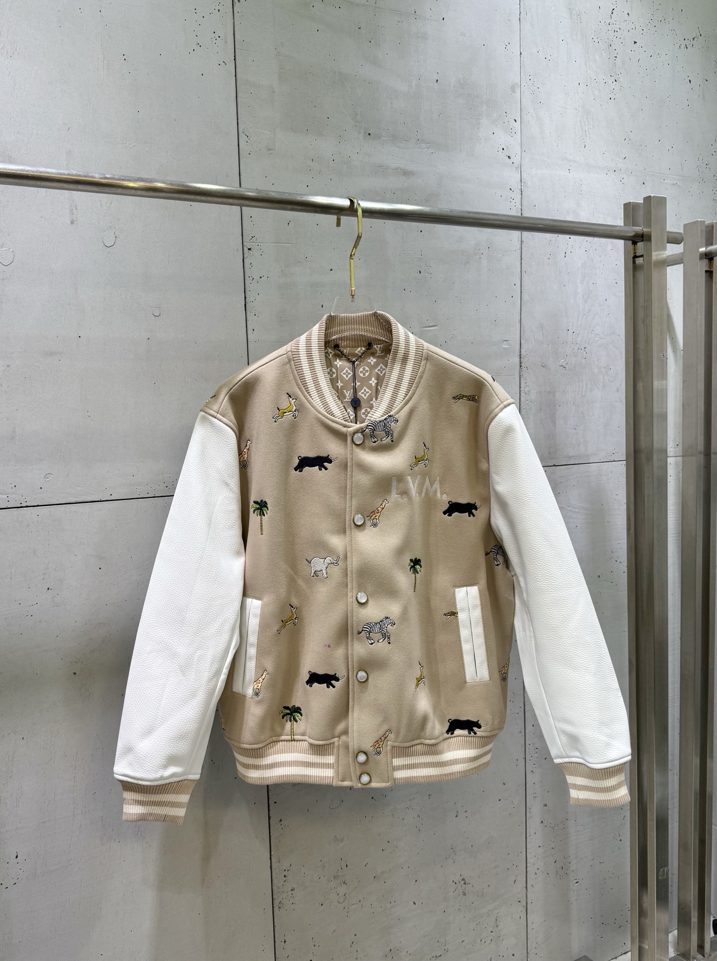 P435 1V/Louis SS26 Chaqueta béisbol de cuero bordada con elemento de patrón animal. Tejido de mezcla de lana beige teji…