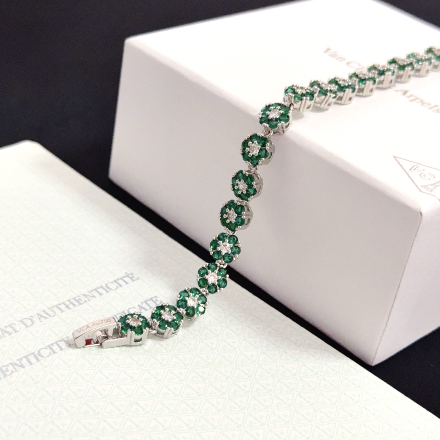 Bracciale Van Cleef Arpels Fleurette metallo oro bianco tonalità argento pietre preziose verde smeraldo diamanti bianchi trasparenti 18 cm