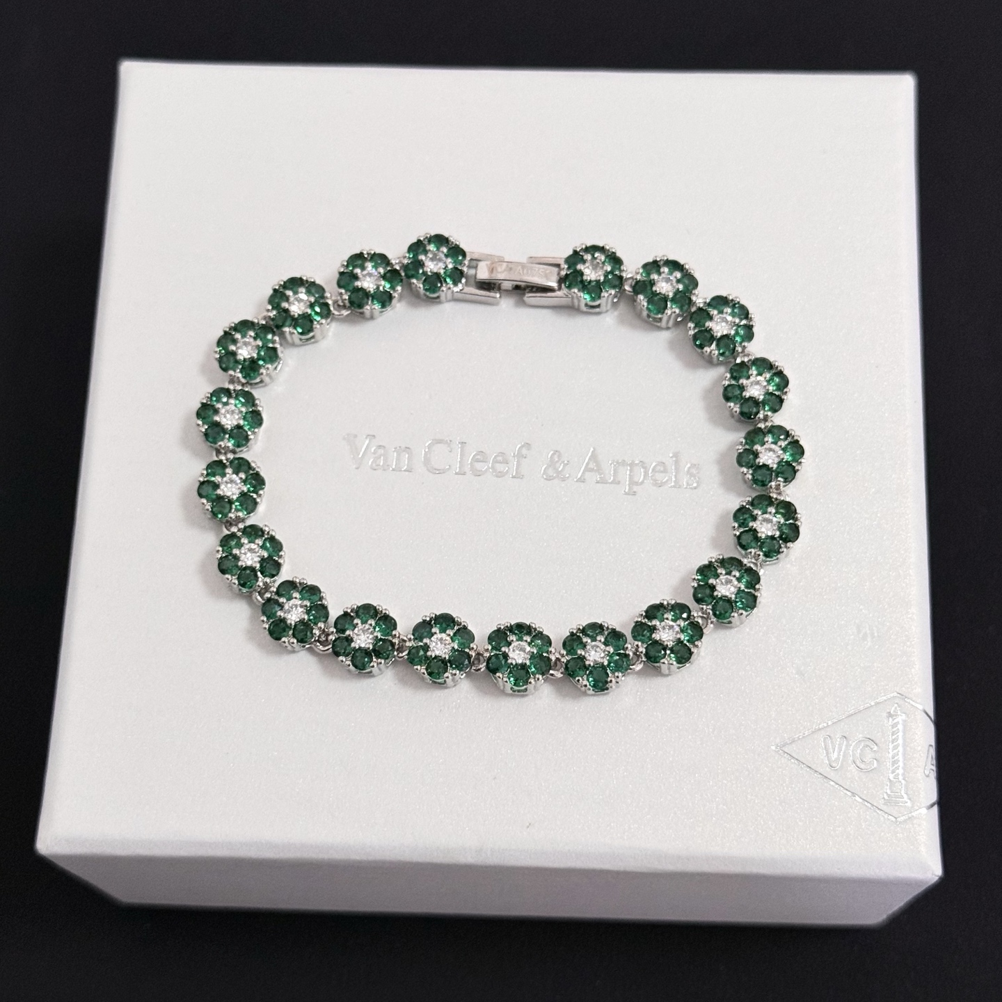 Bracciale Van Cleef Arpels Fleurette metallo oro bianco tonalità argento pietre preziose verde smeraldo diamanti bianchi trasparenti 18 cm