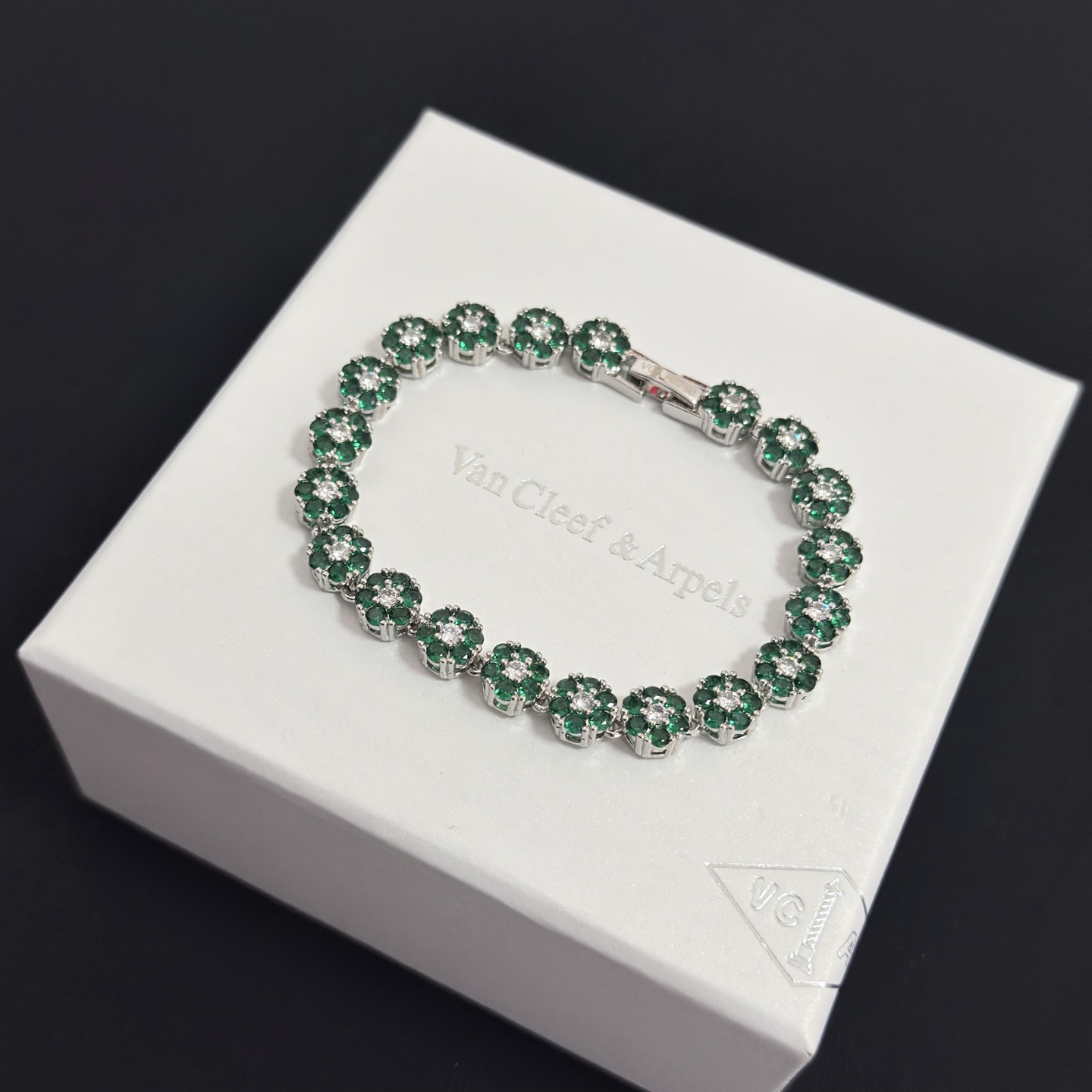 Bracciale Van Cleef Arpels Fleurette metallo oro bianco tonalità argento pietre preziose verde smeraldo diamanti bianchi trasparenti 18 cm