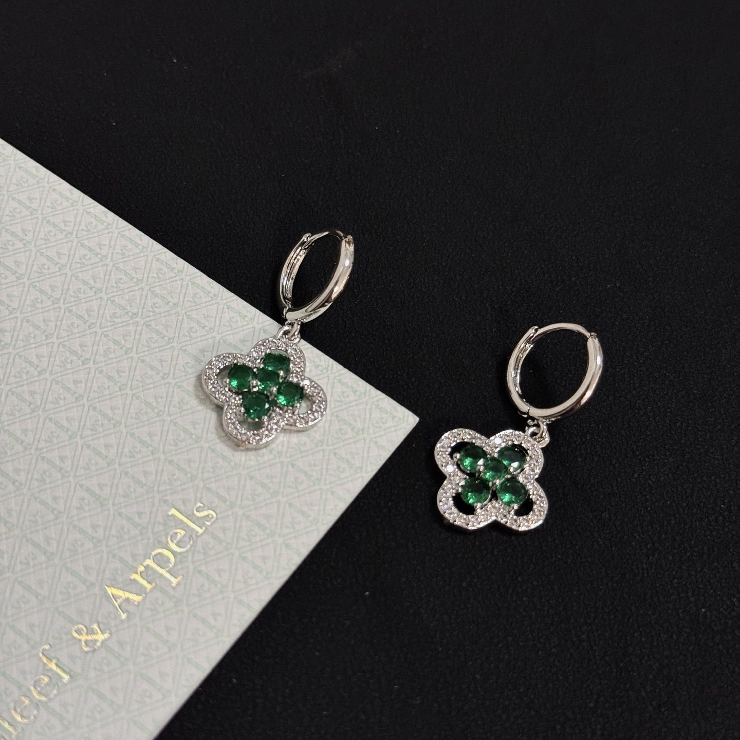 Van Cleef Arpels Alhambra earrings white gold with emerald green gemstones and clear diamond accents 12mm hoop diameter 10mm charm