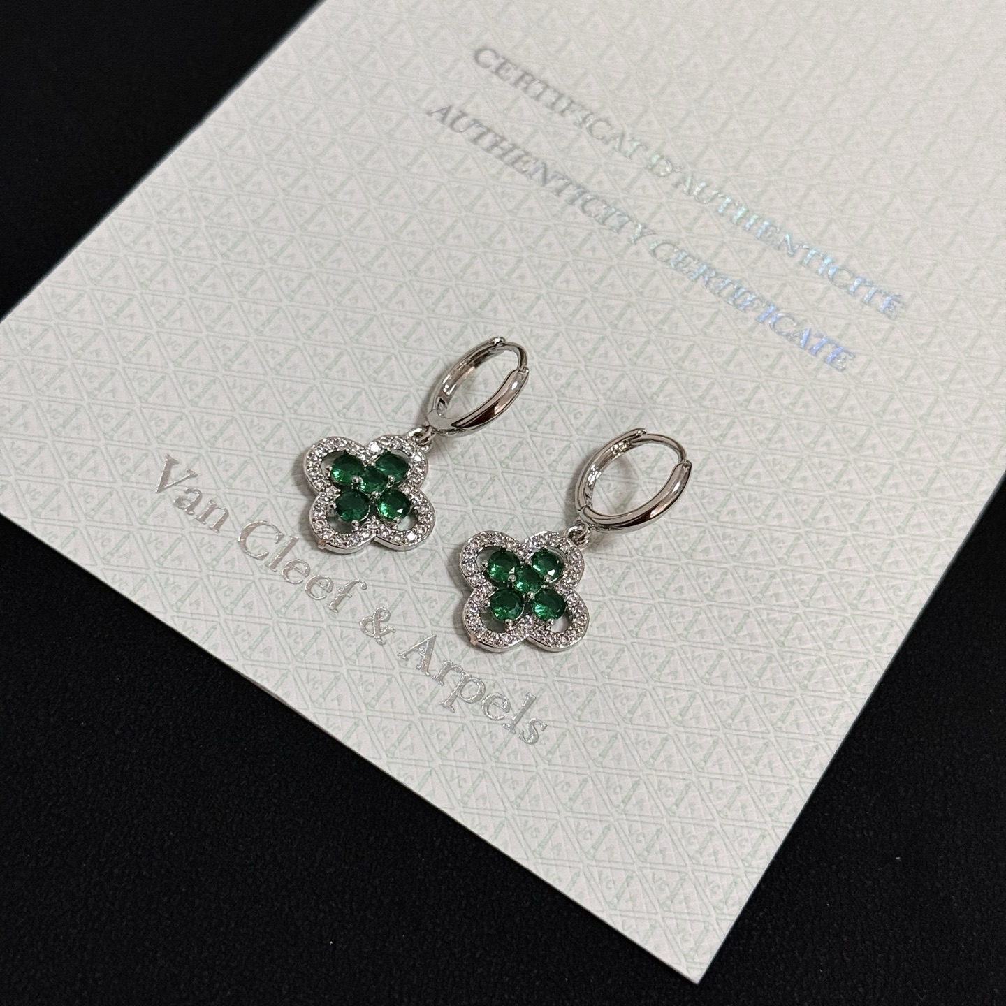 Van Cleef Arpels Alhambra earrings white gold with emerald green gemstones and clear diamond accents 12mm hoop diameter 10mm charm