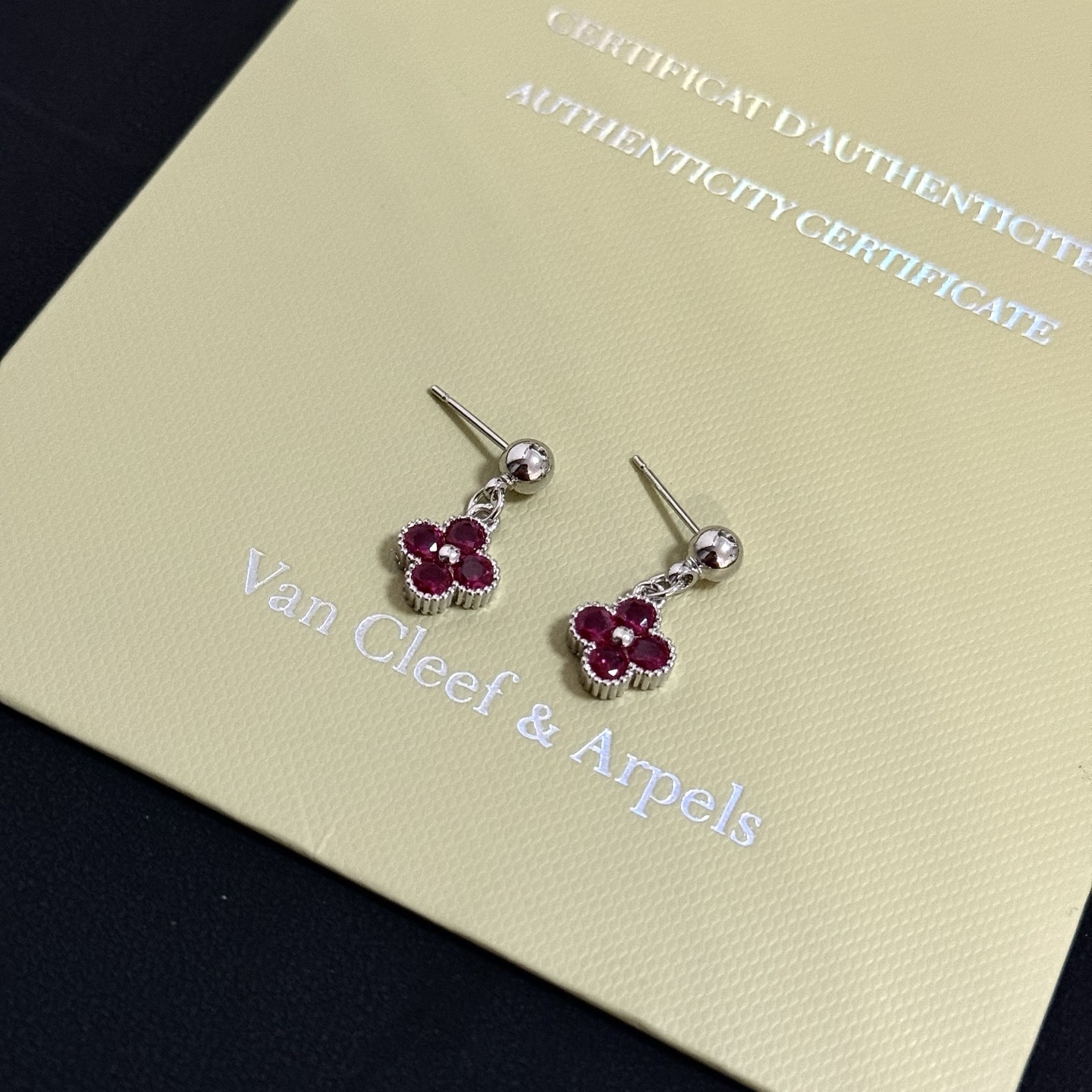 Van Cleef Arpels Alhambra earrings silver-toned white gold metal with deep ruby red gemstones and small white diamond accent 1 5cm drop length