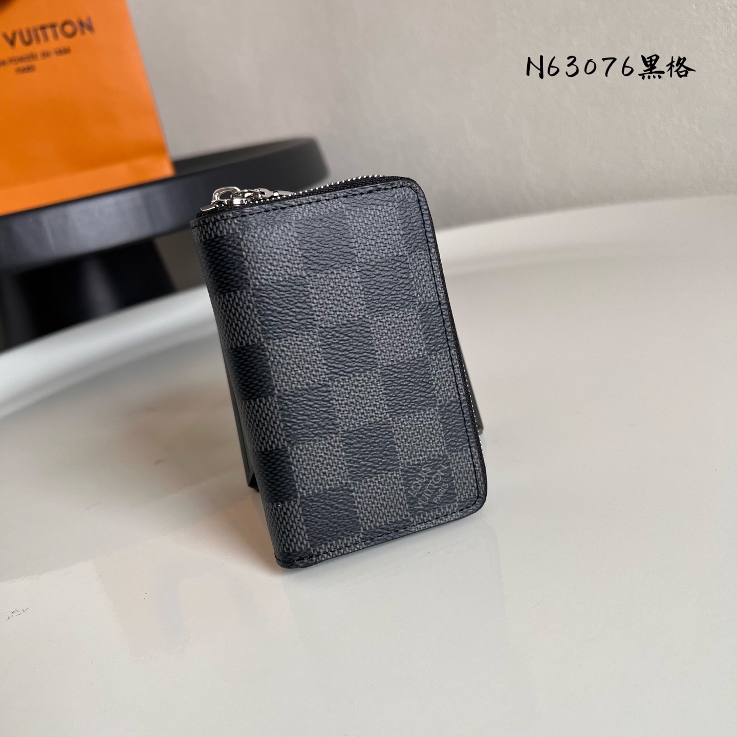  N63076黑格 這款小巧實用的直式拉鏈零錢包以剛陽的Monogram Eclipse帆布製作，配搭牛