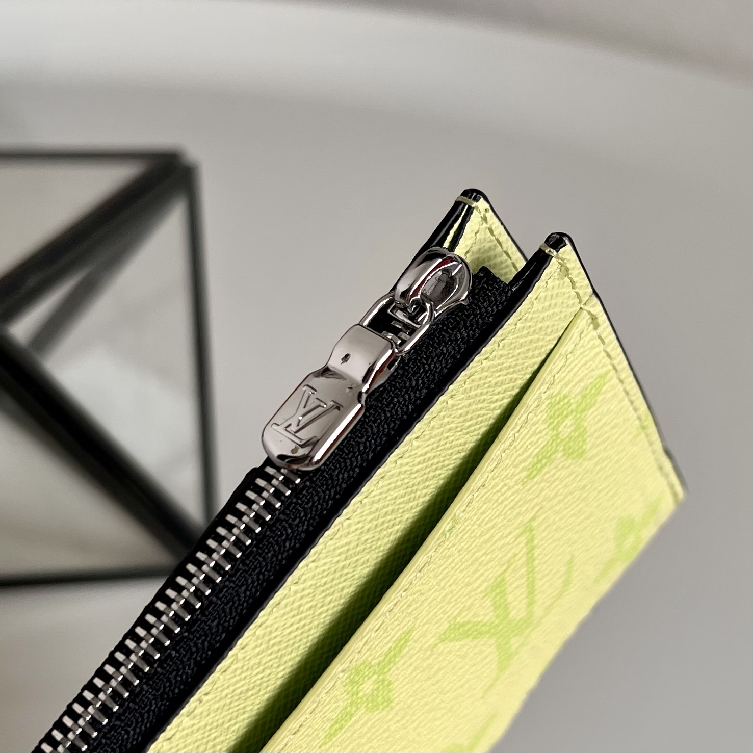  M14109绿色 這款零錢名片夾以Monogram塗層帆布製造，搭配色調相襯的Taïga牛皮，配以黃色
