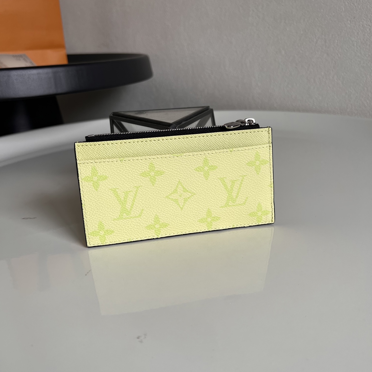  M14109绿色 這款零錢名片夾以Monogram塗層帆布製造，搭配色調相襯的Taïga牛皮，配以黃色