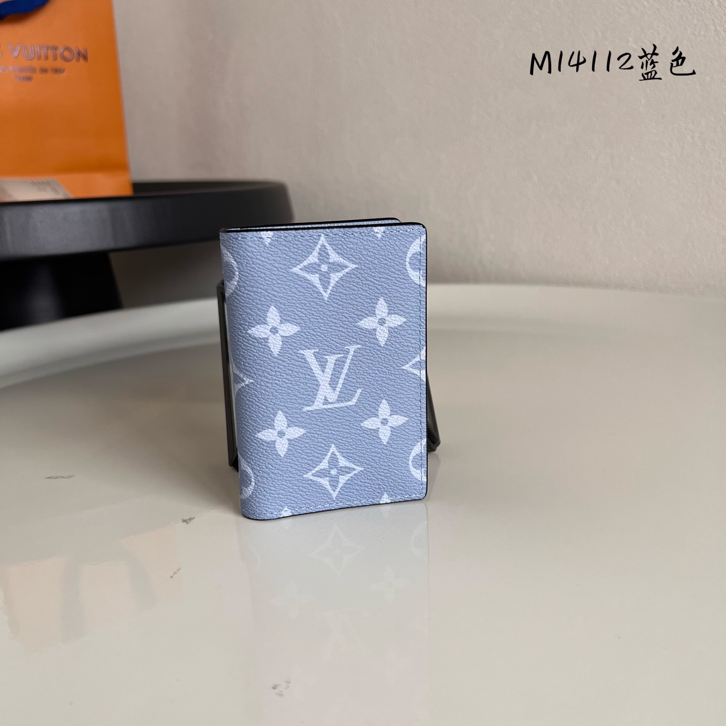  M14112蓝色 這款小巧玲瓏的袋裝萬用錢包採用同色調的Monogram帆布及Taïga皮革製造，以絢