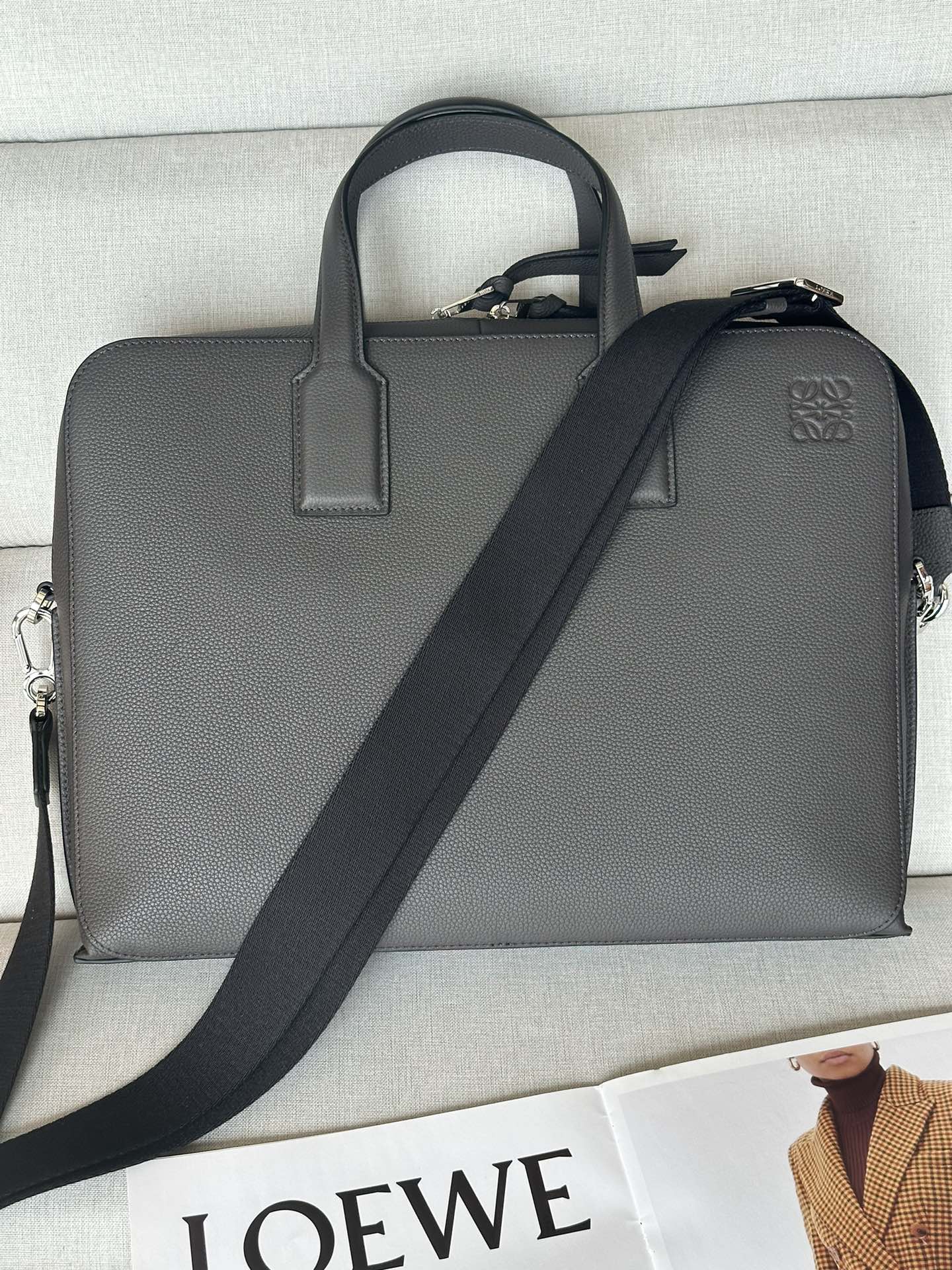 NO:185137,Genuine grade original leather version Lychee leather Deep Coffee Size 27.5-7.5-38 Model 3066 This briefcase is slim and compact in shape and is just right in size. It is suitable for storing documents and daily belongings, ensuring orderly, with abundant internal capacity and multiple compartments. It is neatly designed, with a soft and crisp silhouette. It is made of sturdy and wear-resistant soft grain calf leather. It can be held by the handle or a removable and adjustable webbing shoulder strap to ensure a comfortable feeling during commuting. Main features T-shaped metal accessories, double-head zippered bags with calf leather zipper heads in the same color, herringbone pattern cotton canvas lining, a zipper pocket, a flat compartment with car wire insert pockets, black handmade oil edges, and Anagram pattern embossed in the same color., Superior Loewe, loewe, cowhide19860909正品级 原厂皮版本 荔枝皮 深咖 尺寸27.5-7.5-38 型號3066 这款公文包造型纤薄小巧,尺寸恰到好处,适合收纳文件和日常随身物品,确保井井有条,内部容量充裕,设有多个隔层.设计利落,廓形柔和而又不失挺括,选用坚固耐磨的柔软粒面小牛皮制成.既可拎住手柄,亦可使用可拆可调节的织带肩带背携,确保通勤途中倍感舒适.主要特点T形金属配饰,双头拉链包口搭配同色系小牛皮拉链头,人字纹图案棉质帆布衬里,一个拉链口袋,一个平隔层配有车线插袋,黑色手工油边,同色系Anagram图案压花.,特级罗意威,loewe,cowhide,Bag