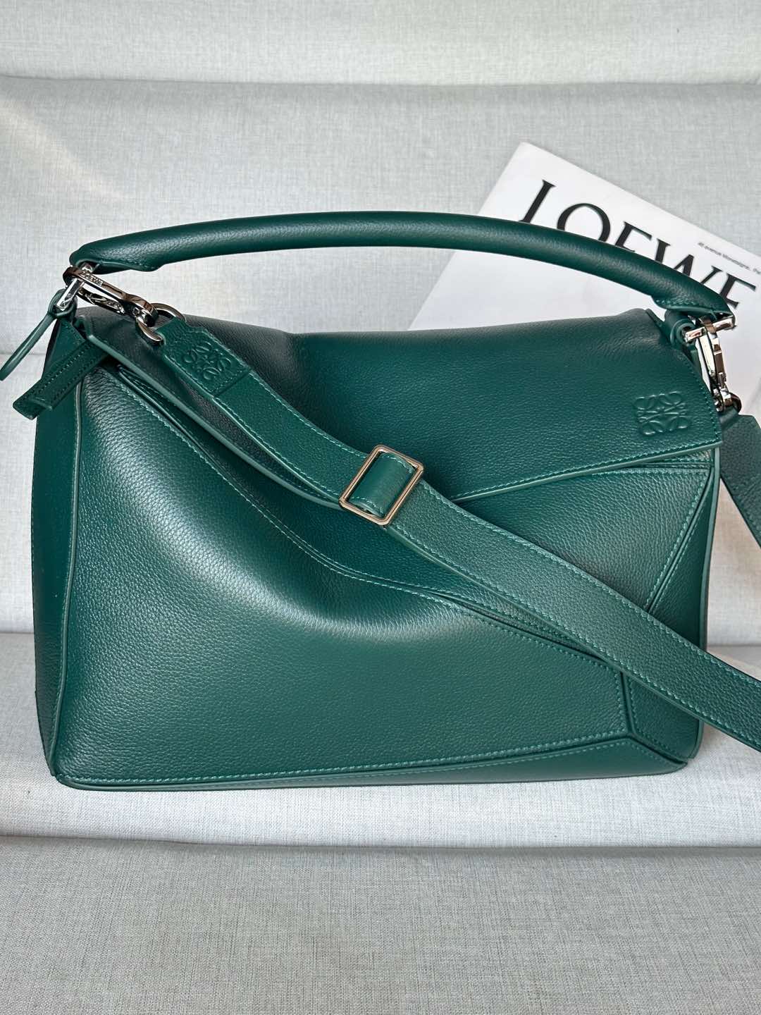 NO:617925,Premium Large Deer Leather Puzzle Bag Color: Evergreen Model 7503 The Puzzle bag is the first handbag launched by Creative Director Jonathan Anderson for LOEWE. The rectangular shape and precise cutting technology create the unique geometric lines of the Puzzle. This large version is made of deer leather. Can be worn on the shoulder, cross-body or hand-carried. Detachable and adjustable shoulder strap. Zipper closure, cow leather zipper puller. One exterior zippered back pocket, two interior slip pockets Suede lining Anagram embossed 33/23/14, premium Loewe, loewe, loewe, cowhide19860909特级 大号鹿皮革 Puzzle 手袋 颜色: 常青綠色型號7503 Puzzle 手袋是创意总监 Jonathan Anderson 为 LOEWE 推出的首款手提包.长方体形状和精确的切割技术创造了 Puzzle 别具一格的几何线条.此大号版本采用鹿皮革制成. 可肩背、斜挎或手提 可拆卸可调节肩带 拉链开合,牛皮革拉链头 一个外部拉链后袋,两个内部插袋 绒面革衬里 Anagram 压纹33/23/14,特级罗意威,loewe,loewe,cowhide,Bag