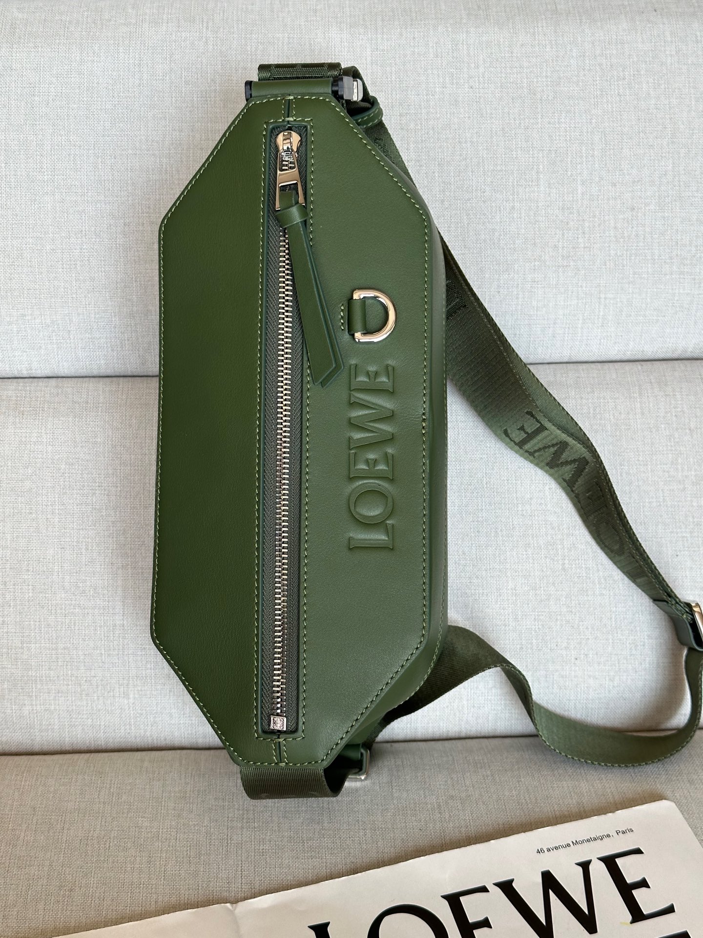 NO:341211,Extra Classic Cowhide Sling Handbag A80 Forest Green Compact Sling Handbags with adjustable LOEWE webbing and brand logo metal buckles that can be opened to change the bag capacity and enable multiple ways to carry. External zippered flat pockets improve functionality. This version is made of classic cowhide leather. Can be carried cross-body or as a waist bag. Zipper closure, cowhide zipper head Herringbone cotton canvas lining Embossed with D-ring LOEWE Color (metal accessories): Palladium Material: cowhide Leather Lining: Fabric Weight: 0.4 kg Size: 32.5*9*12.3cm Product model: A80, premium Roewe, loewe, loewe, cowhide19860909特级 经典牛皮革变形 Sling 手袋 A80 森林绿色 紧凑型 Sling 手袋配有可调节 LOEWE 织带和品牌标志金属搭扣,可打开以改变手袋容量并实现多种携带方式.外部拉链平口袋进步增强了功能性.这个版本采用经典牛皮革制成. 可斜挎或作为腰包携带. 拉链开合,牛皮革拉链头 人字纹棉质帆布衬里 配有 D 形环的压纹 LOEWE 颜色（金属配件）:钯金色 材质:牛皮革 里料:织物 重量:0.4 kg 尺寸:32.5*9*12.3cm 商品型号:A80,特级罗意威,loewe,loewe,cowhide,Bag