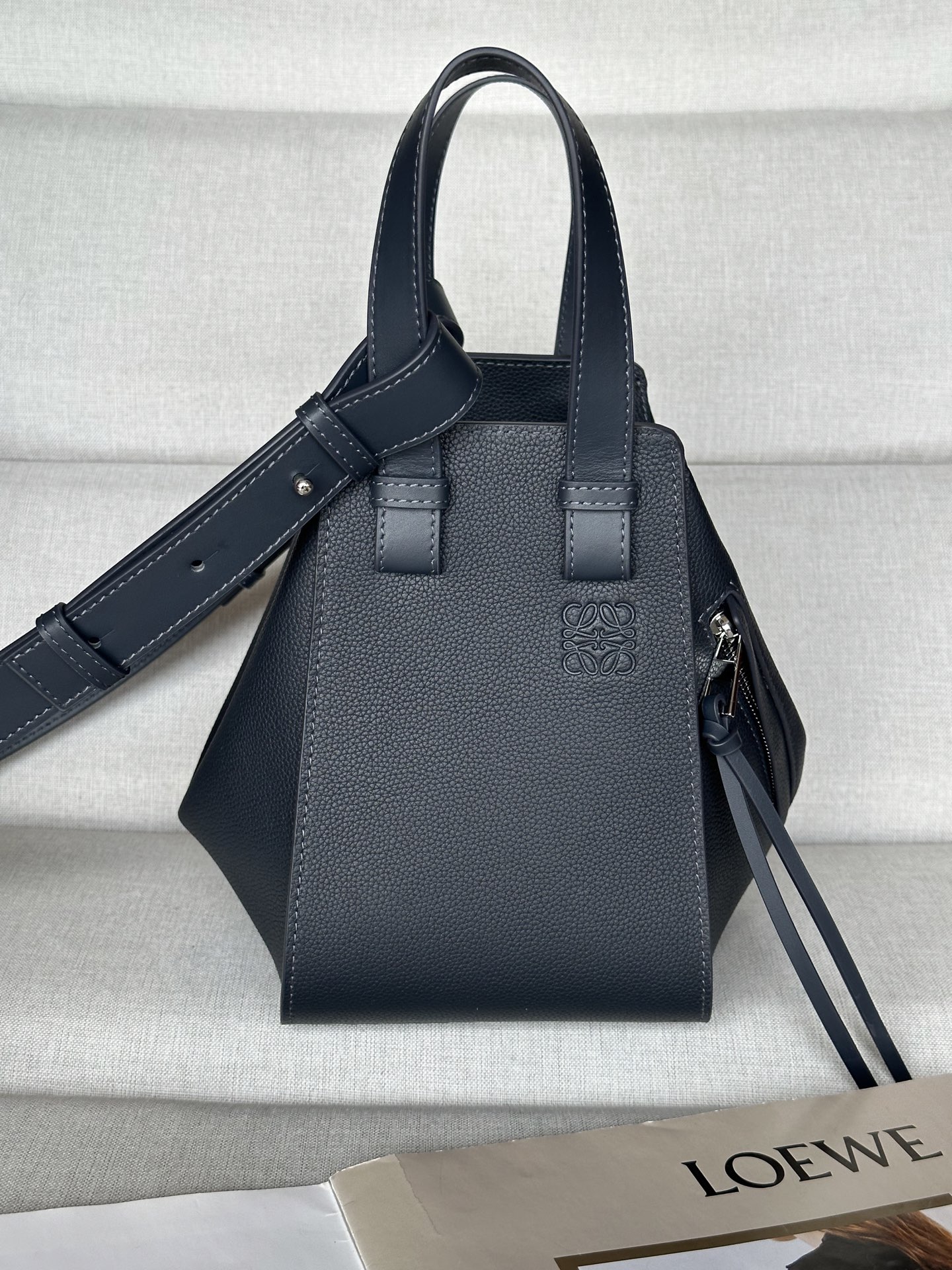 NO:187264,Extra-grade version Original leather loewe hammock compact version. Dark blue between mini and small Model 8047 compaet version New size 20-19-14 Hammock is a multi-purpose handbag with soft side bread that releases the sides to change shape. The loop strap allows the handbag to be worn in a variety of ways. This new compact version is made of soft grain cowhide leather Crossbody, shoulder back or carried through top handle Removable, adjustable shoulder strap Internal hook closure Two internal insert pockets, one external zipper pocket Customizable with shoulder straps and personalized hanging Herringbone cotton canvas lining Anagram embossed, super-grade Loewe, loewe, cowhide19860909特级版本 原厂皮 loewe hammock紧凑版本. 深藍 介于mini跟小号中间 型号8047 compaet珍版本 新尺寸20-19-14 Hammock 是一款带有柔软侧面包身的多功能手袋,可释放侧面来改变形状. 环状带子可以使手袋有多种佩戴方式. 这个全新的紧凑版本采用柔软粒面牛皮革制成 斜挎,肩背或通过顶部提手携带 可拆卸,可调节肩带 内部钩扣封口 两个内部插袋,一个外部拉链口袋 可以使用肩带和个性化挂饰进行定制 人字纹棉帆布衬里 Anagram 压纹,特级罗意威,loewe,loewe,cowhide,Bag