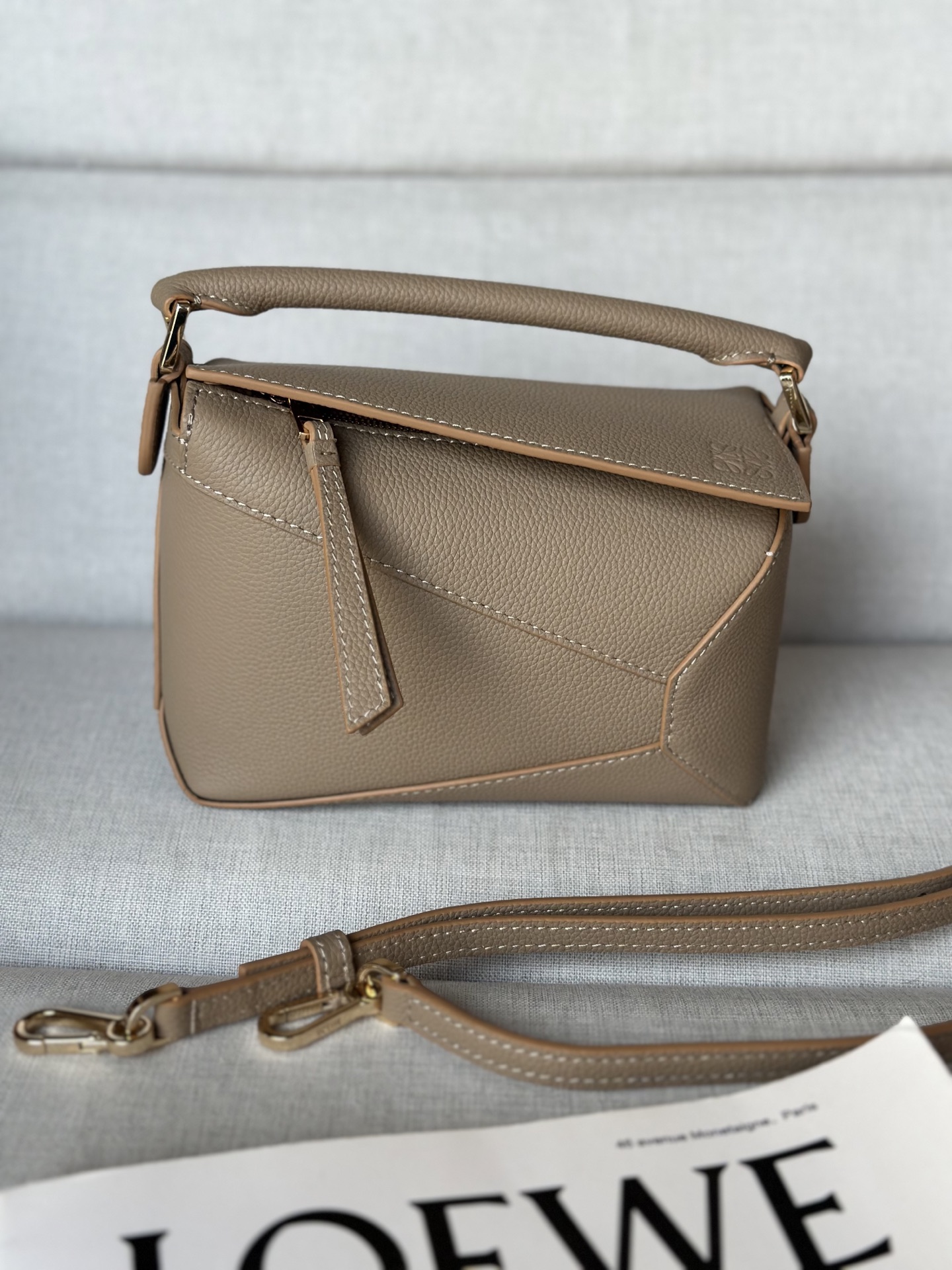 NO:340690,Super Puzzle Edge handbag Latest version adjustable shoulder straps Sand color Lo*we debuts debut handbag* rectangular shape and precise cutting technology create Puzzle unique geometric lines* This mini version is made of satin cowhide leather with cage stitching edges Mini Puzzle can accommodate for example a small vertical wallet, most sizes of phones (up to 6.1 inches) and sunglasses case, shoulder or crossbody* adjustable shoulder straps, removable*zipper closure, *coat leather zipper head*herring cotton canvas lining Anagram embossed size: 18*12.5*8CＭ Model 3000b, super Loewe, wallets, cowhide19860909特级 Puzzle Edge 手袋 最新版本肩带可调节 沙色 Lo*we推出的首次亮相手提包*长方体形状和精确的切割技术创造了 Puzzle 独特的几何线条*这个迷你版本采用缎面牛皮革制成,带有笼盖缝线边缘 迷你Puzzle可以容纳例如一只小号垂直钱包、大多数尺寸的手机（最大6.1英寸）和太阳镜盒,肩背或斜挎*肩带可调节,可拆卸*拉链封口,*牛皮革拉链头*人字纹棉质帆布衬里Anagram 压纹 size:18*12.5*8CＭ 型号3000b,特级罗意威,loewe,wallets,cowhide,Bag