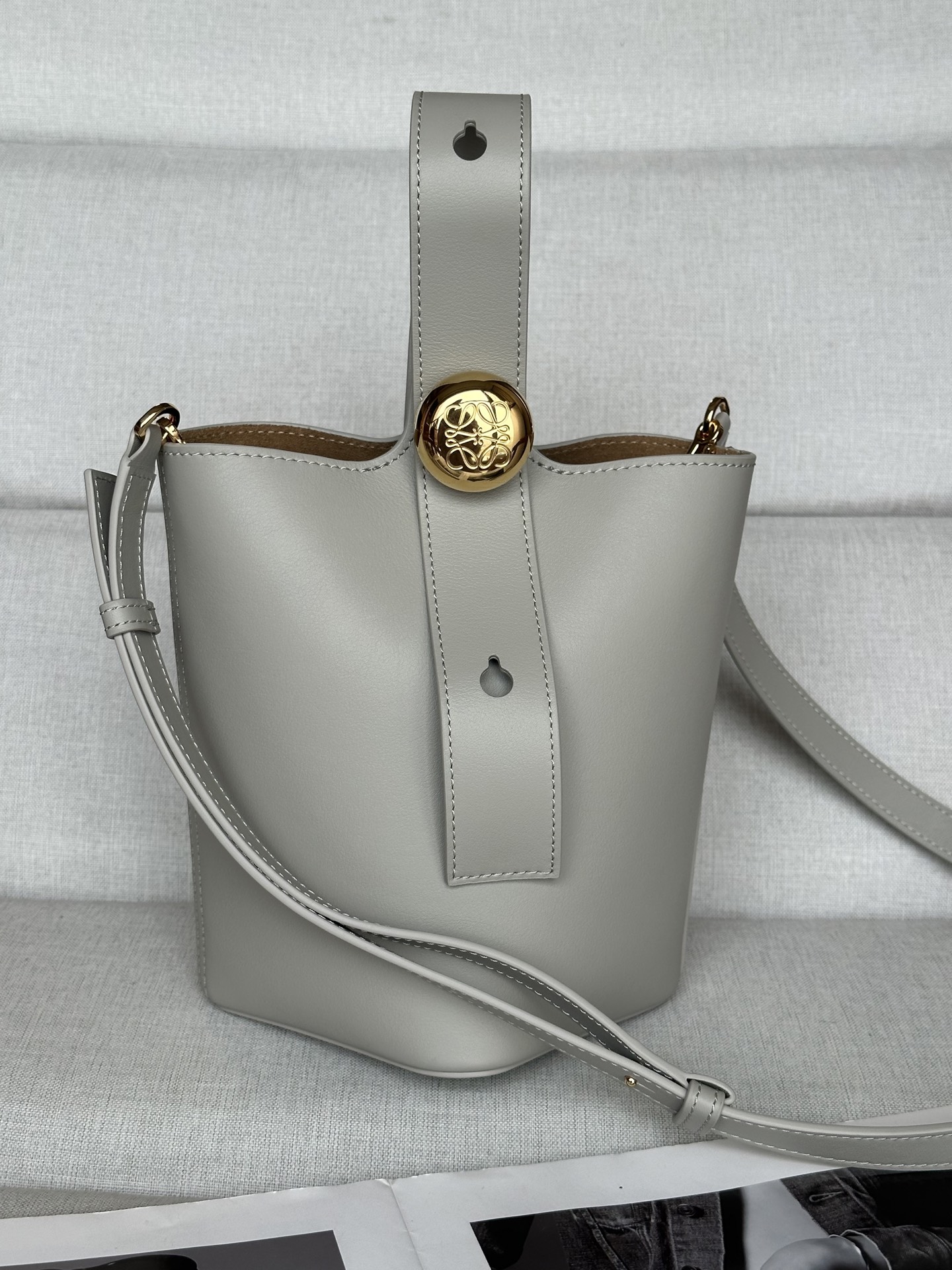 NO:186897,Superior leather Pebble Bucket Moonlight Gray Bucket Handbag Pebble cleverly blends pure simple lines with eye-catching design style to create a unique and innovative handbag design. The iconic Anagram engraving hardware combines decorative and practical functions, adjusts the length of the shoulder strap and is suitable for a variety of carrying methods. The unique twisted structure complements the delicate details. This mini version is made of soft grain cowhide. It can be cross-body, shoulder or hand-held * Adjustable removable shoulder strap * Magnetic buckle opening and closing * Inner bag * Synthetic leather lining * Anagram engraving pebble model number 332s Dimensions 20CM ~ 16CM ~ 13, special Loewe, cowhide19860909特级 原厂皮 Pebble Bucket 月光灰 水桶手袋Pebble将纯粹的简约线条与瞩目设计风格巧妙融合造就别具一格的创新的手袋设计.标志性的 Anagram 雕刻五金件兼具装饰和实用功能,可调节肩带长度并适合多种携带方式,独特的扭曲结构与微妙的细节相得益彰.此迷你版本采用柔软粒面牛皮革制成.可斜挎、肩背或手提＊可调节可拆卸肩带＊磁扣开合＊内袋＊合成革衬里* Anagram 雕刻卵石 款号332s 尺寸高20CM～袋口16CM～13,特级罗意威,loewe,cowhide,Bag