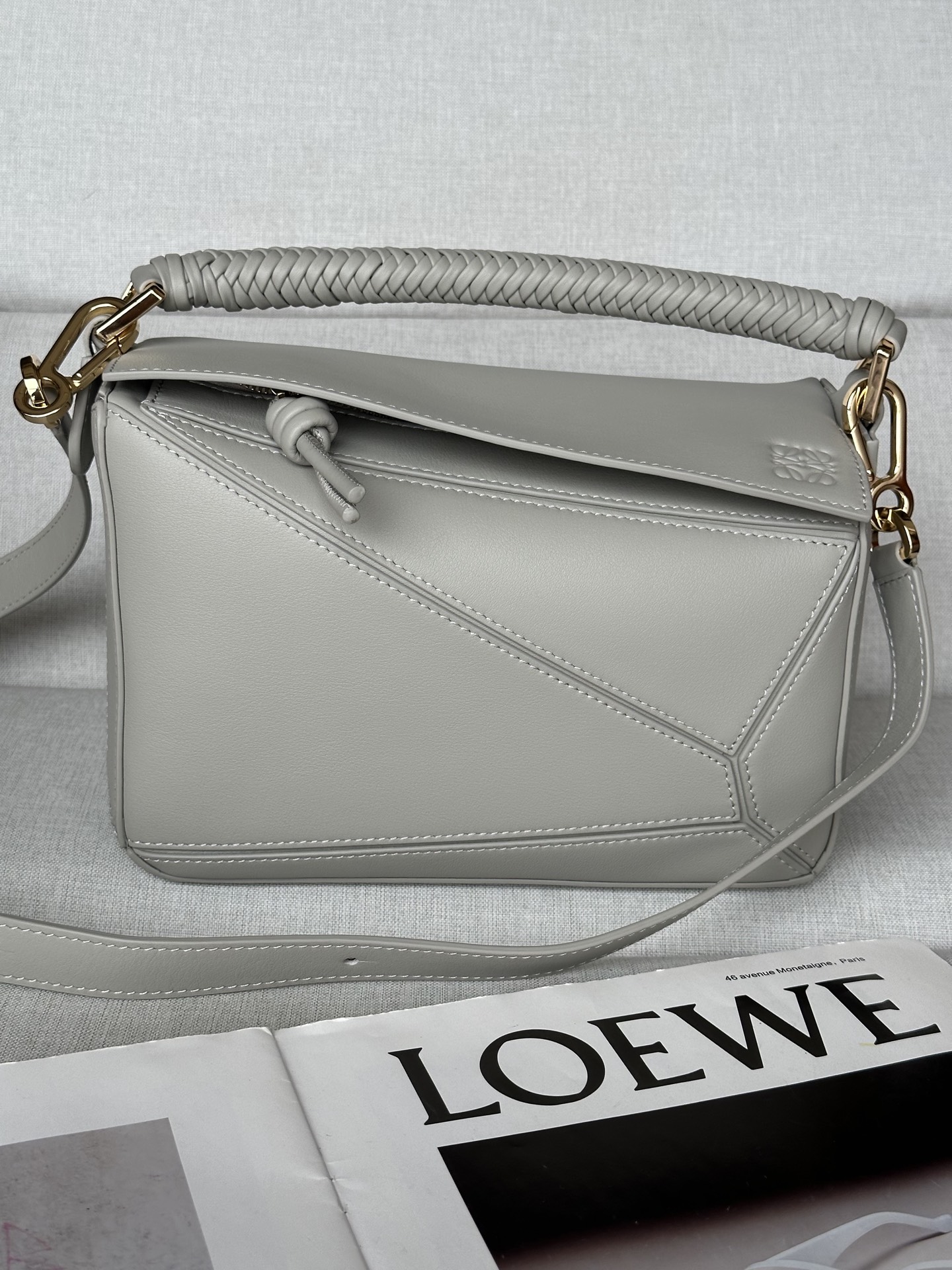 NO:187301,Superior version Original leather Puzzle Shell Gray New small soft cowhide leather Puzzle handbag is creative director Jonathan. Jonathan Anderson created Puzzle’s unique geometric lines for the first handbag rectangular shape and precise cutting technology for LOEWE. This small version is made of soft cowhide leather with a unique braided handle.＊This small Puzzle handbag can hold, for example, a large wallet, all sizes of mobile phones and sunglasses in all sizes, shoulder-mounted, cross-body, hand-holding or hand-holding removable adjustable shoulder straps * Zipper-closed cowhide zipper head with an external zipper rear pocket and an internal insert bag * Customized with shoulder straps and personalized hangings * Suede lining * Anagram embossed Size 24cm~10.5cm~16.5cm Model No. 97018, special Loewe, loewe, wallets, cowhide19860909特级版本  原厂皮 Puzzle 貝殼灰 新款小号柔软牛皮革Puzzle 手袋是创意总监乔纳森．安德森( Jonathan Anderson）为 LOEWE 推出的首款手提包长方体形状和精确的切割技术创造了 Puzzle 独特的几何线条此小号版本采用柔软牛皮革制成搭配独特的编织手提.＊这款小号 Puzzle 手袋可容纳例如一只大号钱包所有尺寸的手机和太阳镜可肩背、斜挎、手提或手拿可拆卸可调节肩带＊拉链开合牛皮革拉链头外部拉链后袋和一个内部插袋＊可以使用肩带和个性化挂饰进行定制＊绒面革衬里＊ Anagram 压纹 尺寸24cm～10.5cm～16.5cm 款号97018,特级罗意威,loewe,loewe,wallets,cowhide,Bag