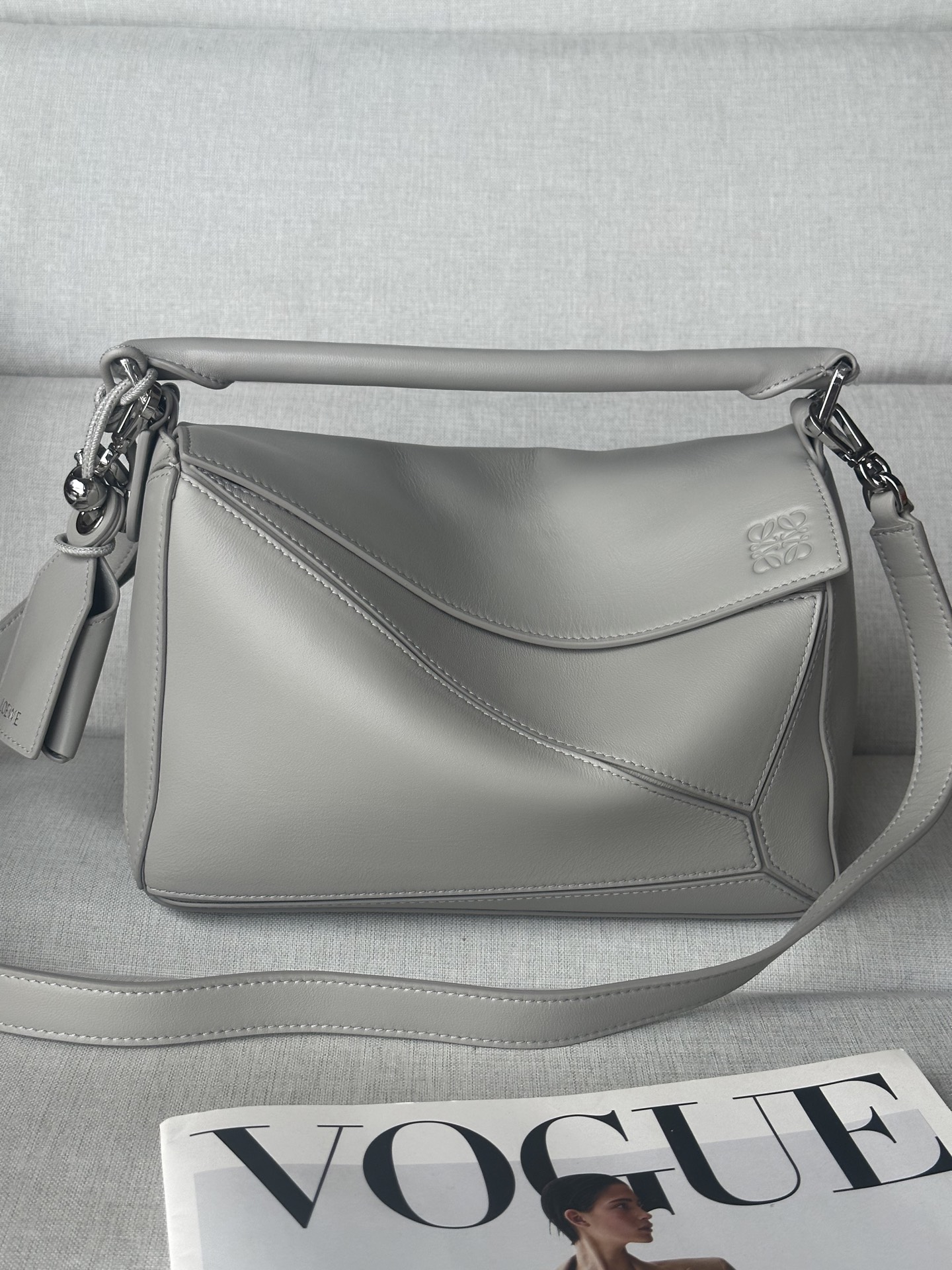 NO:580688,Special Grade New Product 3007 Sheepskin Shell Gray Small Nappa Sheep Leather Featherlight Puzzle Handbag Featherlight Puzzle outlines a rectangular shape with unique geometric lines. The soft and lightweight nappa leather injects a casual and lazy style into the handbag. It can be carried on the shoulder, crossbody or handbag. Detachable and adjustable shoulder strap, decorated with rotating buckle. Zipper closure, hinged zipper puller.  One external zippered back pocket, one internal slip pocket Removable LOEWE hot stamping or silver stamping label, decorated with secret pockets and balloon dice Rectangular metal feet Napa sheep leather lining Anagram embossing, plaque engraved inside LOEWE size: 24*10.5*16.5cm, premium Loewe, loewe, loewe, sheepskin19860909特级 新品 3007 羊皮 贝壳灰色 小号纳帕羊皮革 Featherlight Puzzle 手袋 Featherlight Puzzle 以别具一格的几何线条勾勒长方体造型.柔软轻盈的纳帕皮革为手袋注入随性慵懒的风格. 可肩背、斜挎或手提 可拆卸可调节肩带,饰有旋转卡扣 拉链开合,铰接式拉链头 一个外部拉链后袋,一个内部插袋 可拆卸 LOEWE 烫金或烫银标签,饰有隐秘口袋和气球骰子 长方形金属脚钉 纳帕羊皮革衬里 Anagram 压纹、饰牌内部镌刻 LOEWE尺寸:24*10.5*16.5cm,特级罗意威,loewe,loewe,sheepskin,Bag
