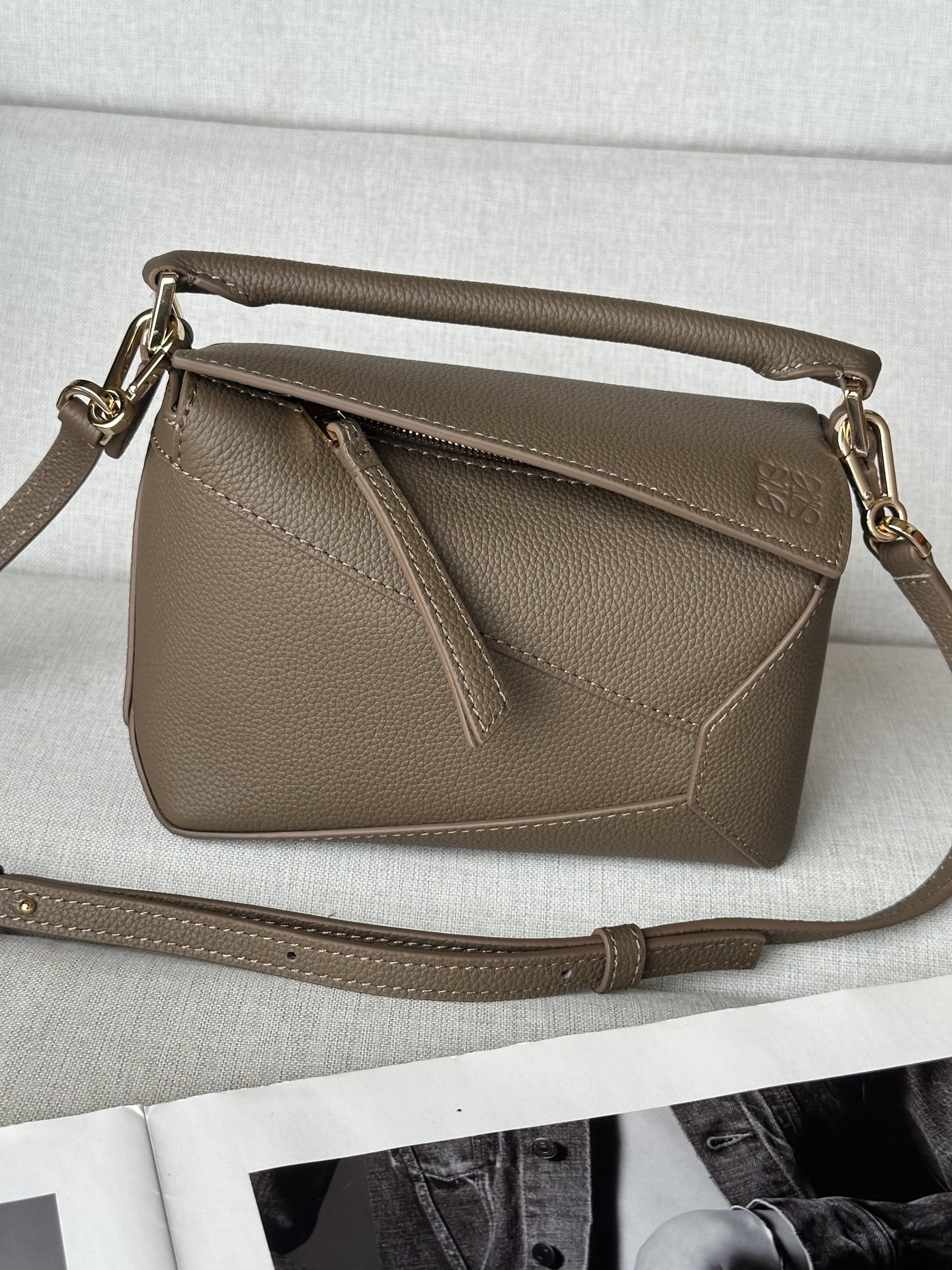 NO:340061,Extra Mini Taupe Handbag Latest version adjustable shoulder straps Lo*we debuts the first-time handbag* rectangular shape and precise cutting technology create Puzzle’s unique geometric lines* This mini version is made of satin cowhide leather with cage stitching edges Mini Puzzle can accommodate for example a small vertical wallet, most sizes of phones (up to 6.1 inches) and sunglasses case, shoulder or crossbody* adjustable shoulder straps, removable*zipper closure, *coat leather zipper head*herring cotton canvas lining Anagram embossed size: 18*12.5*8CＭ Model 3000b, special Loewe, wallets, cowhide19860909特级 mini灰褐色 手袋 最新版本肩带可调节 Lo*we推出的首次亮相手提包*长方体形状和精确的切割技术创造了 Puzzle 独特的几何线条*这个迷你版本采用缎面牛皮革制成,带有笼盖缝线边缘 迷你Puzzle可以容纳例如一只小号垂直钱包、大多数尺寸的手机（最大6.1英寸）和太阳镜盒,肩背或斜挎*肩带可调节,可拆卸*拉链封口,*牛皮革拉链头*人字纹棉质帆布衬里Anagram 压纹 size:18*12.5*8CＭ 型号3000b,特级罗意威,loewe,wallets,cowhide,Bag