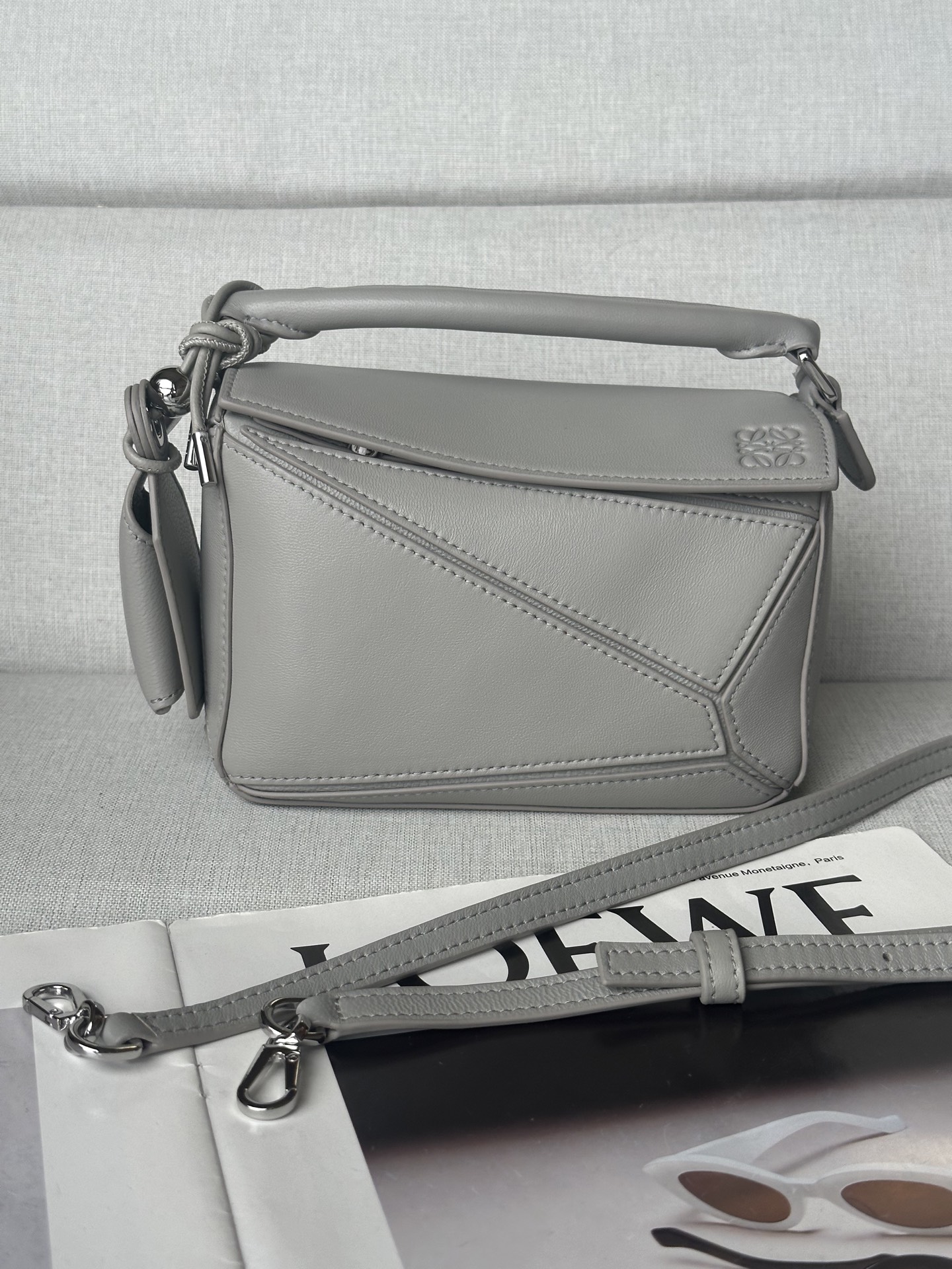 NO:339947,Superior loewe Shell Gray Mini Napa Sheep Leather Featherlight Puzzle Handbag Model Featherlight Puzzle outlines the rectangular shape with unique geometric lines. Soft and lightweight Napa leather injects casual and lazy style into the handbag. Shoulder, crossbody or handheld Removable adjustable shoulder strap with rotary snaps, top handle Zipper closure, articulated zipper head Removable LOEWE gold or silver label with secret pockets and balloon dice Rectangular metal foot nails Napa Sheep Leather lining Anagram embossed, engraved with LOEWE on the inside Size: 17.5*7.5*12.5cm, Superior Loewe, loewe, sheepskin19860909特级 loewe 贝壳灰 迷你纳帕羊皮革 Featherlight Puzzle 手袋 型号 Featherlight Puzzle 以别具一格的几何线条勾勒长方体造型.柔软轻盈的纳帕皮革为手袋注入随性慵懒的风格. 可肩背、斜挎或手提 可拆卸可调节肩带饰有旋转卡扣,顶部提手 拉链开合,铰接式拉链头 可拆卸 LOEWE 烫金或烫银标签,饰有隐秘口袋和气球骰子 长方形金属脚钉 纳帕羊皮革衬里 Anagram 压纹、饰牌内侧刻有 LOEWE 尺寸:17.5*7.5*12.5cm,特级罗意威,loewe,loewe,sheepskin,Bag