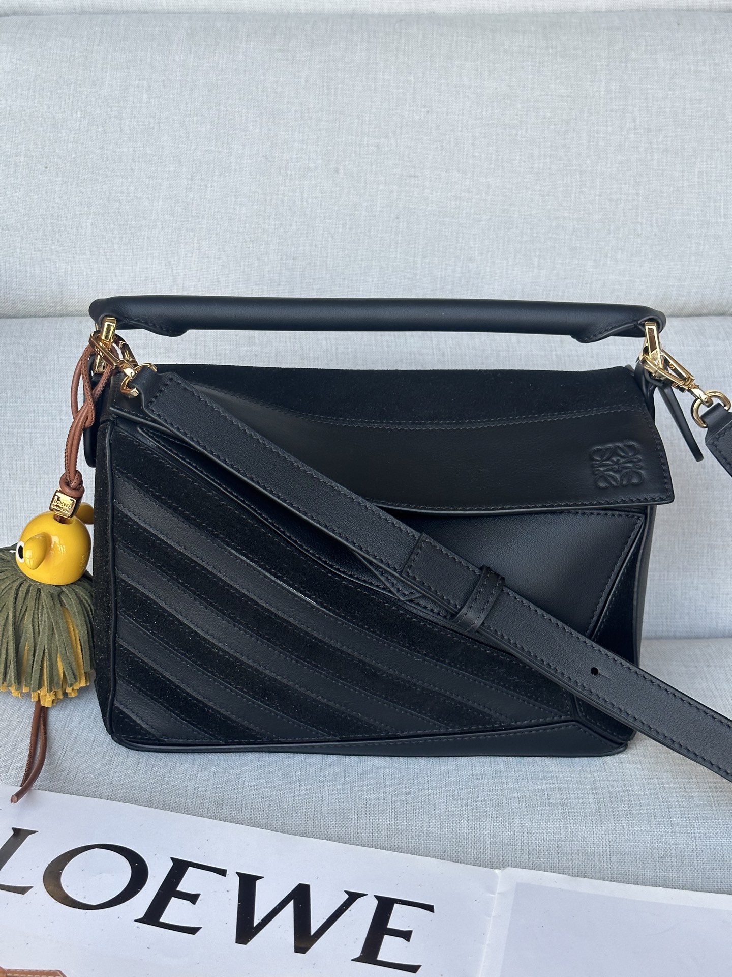 NO:341122,Super Puzzle f3001 Black The bag is made of unique geometric lines to create a rectangular shape. The small version is made of classic calfskin and suede with inlay stripes with specific color patterns. It can be shoulder, cross-back or hand-held strap adjustable and detachable Zipper with calfskin zipper head One exterior zipper back pocket and one internal insert pocket Anagram embossed cm in color Black Metallic Gold Material Classic calfskin/suede Shoulder strap length 80.5 - .5 cm Strap length 40 - 58 cm Handle height 7 cm Weight 0. kg Height 16.5 cm Width 24 cm Depth 10.5 cm Originated from, Loewe, cowhide, chamois leather19860909特级 Puzzle f3001 黑色 包款以獨樹一格的幾何線條造就長方體造型.小型版本以經典小牛皮和麂皮製成,飾有特定配色圖案的嵌花條紋. 可肩背、斜背或手提 肩帶可調整拆卸 拉鍊附小牛皮拉鍊頭 一個外部拉鍊後袋,一個內部插袋 Anagram 壓紋 公分·in 顏色 黑色 金屬色 金色 材質 經典小牛皮/麂皮 肩背帶長度 80.5 - .5 cm 肩帶長度 40 - 58 cm 把手高度 7 cm 重量 0. kg 高 16.5 公分 寬 24 公分 深 10.5 公分 產自,特级罗意威,loewe,cowhide,chamois leather,Bag