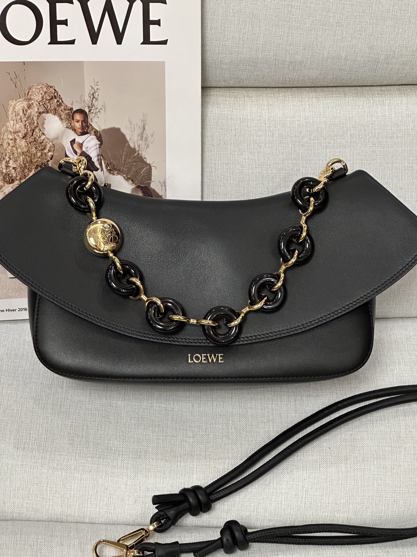 NO:617930,Premium loewe model 7019 black size 26-18-13 Ola is a soft, lightweight and versatile summer bag with a curved body, a smooth flap and a stylish donut chain strap. Medium version in smooth calfskin. Detachable tubular calfskin shoulder strap, detachable donut chain flap One inner pocket LOEWE hot stamping, engraved Anagram Sand smooth calfskin Shoulder strap length 37/97-61 cm shoulder strap length 15/31-56 cm, premium Loewe, loewe, loewe, cowhide19860909特级 loewe 型号7019 黑色 尺寸26-18-13 Ola 是柔軟輕巧且靈活百搭的夏季包款,採用弧形包身、線條流暢的翻蓋和時尚甜甜圈鍊帶.中型版本以平滑小牛皮製成. 可拆式管狀小牛皮肩帶,可拆式甜甜圈鍊帶 翻蓋 一個內袋 LOEWE 燙金,鐫刻 Anagram 沙色 光滑小牛皮 肩背帶長度 37/97-61 cm 肩帶長度 15/31-56 cm,特级罗意威,loewe,loewe,cowhide,Bag