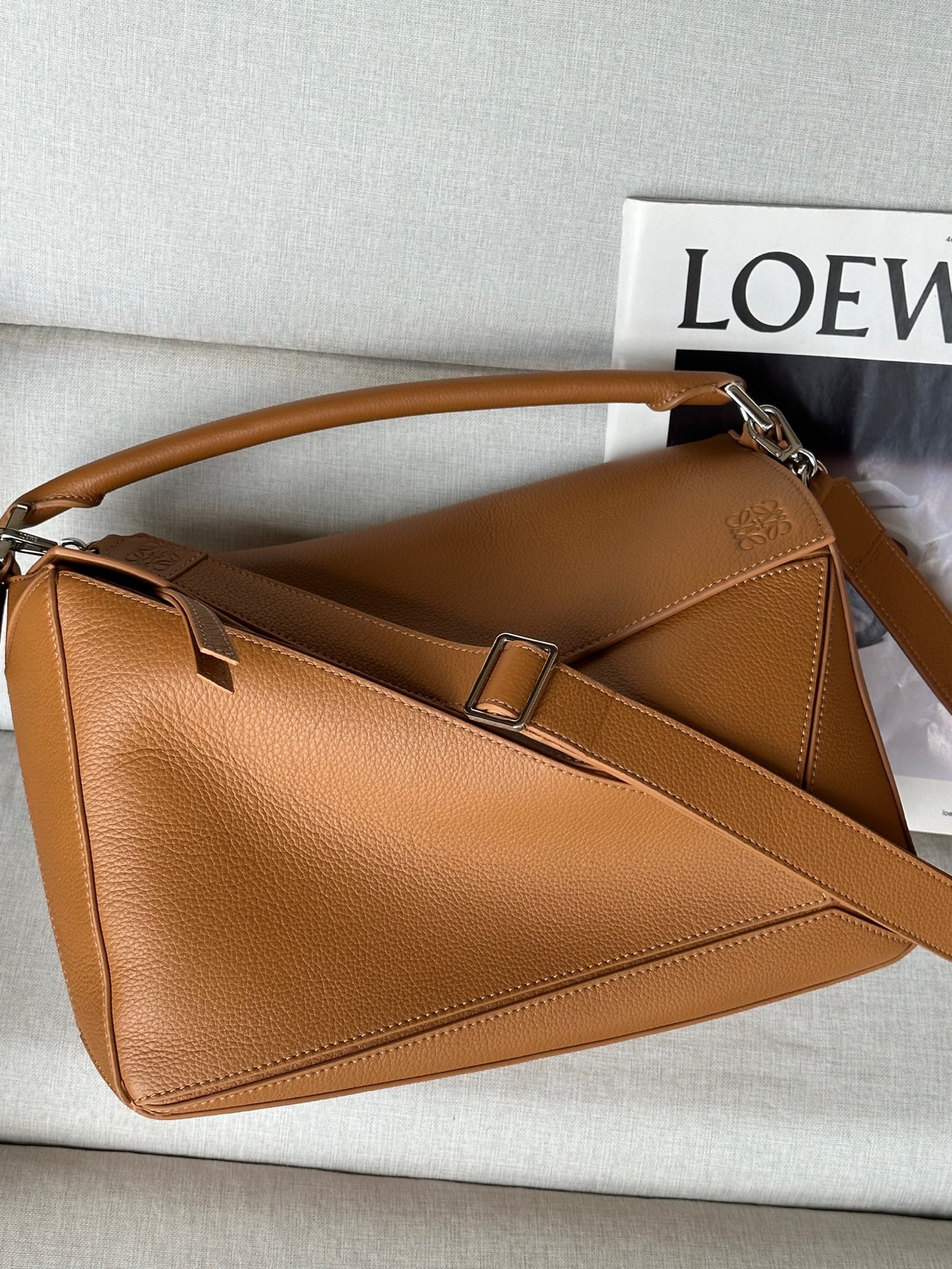 NO:341207,Extra New Large Deer Leather Puzzle Handbag Color: Classic Brown Model 7503 Puzzle Handbag is the first tote bag for LOEWE by creative director Jonathan Anderson. The rectangular shape and precise cutting technology create the unique geometric lines of the Puzzle. This large version is made of deer Leather. Shoulder, crossbody or handheld Removable and adjustable shoulder straps Zipper closure, cowhide zipper head One exterior zipper rear pocket, two internal insert pockets Suede lining Anagram embossed 33/23/14, Extra Loewe, loewe, loewe, cowhide19860909特级 新品 大号鹿皮革 Puzzle 手袋 颜色: 經典棕色 型號7503 Puzzle 手袋是创意总监 Jonathan Anderson 为 LOEWE 推出的首款手提包.长方体形状和精确的切割技术创造了 Puzzle 别具一格的几何线条.此大号版本采用鹿皮革制成. 可肩背、斜挎或手提 可拆卸可调节肩带 拉链开合,牛皮革拉链头 一个外部拉链后袋,两个内部插袋 绒面革衬里 Anagram 压纹33/23/14,特级罗意威,loewe,loewe,cowhide,Bag