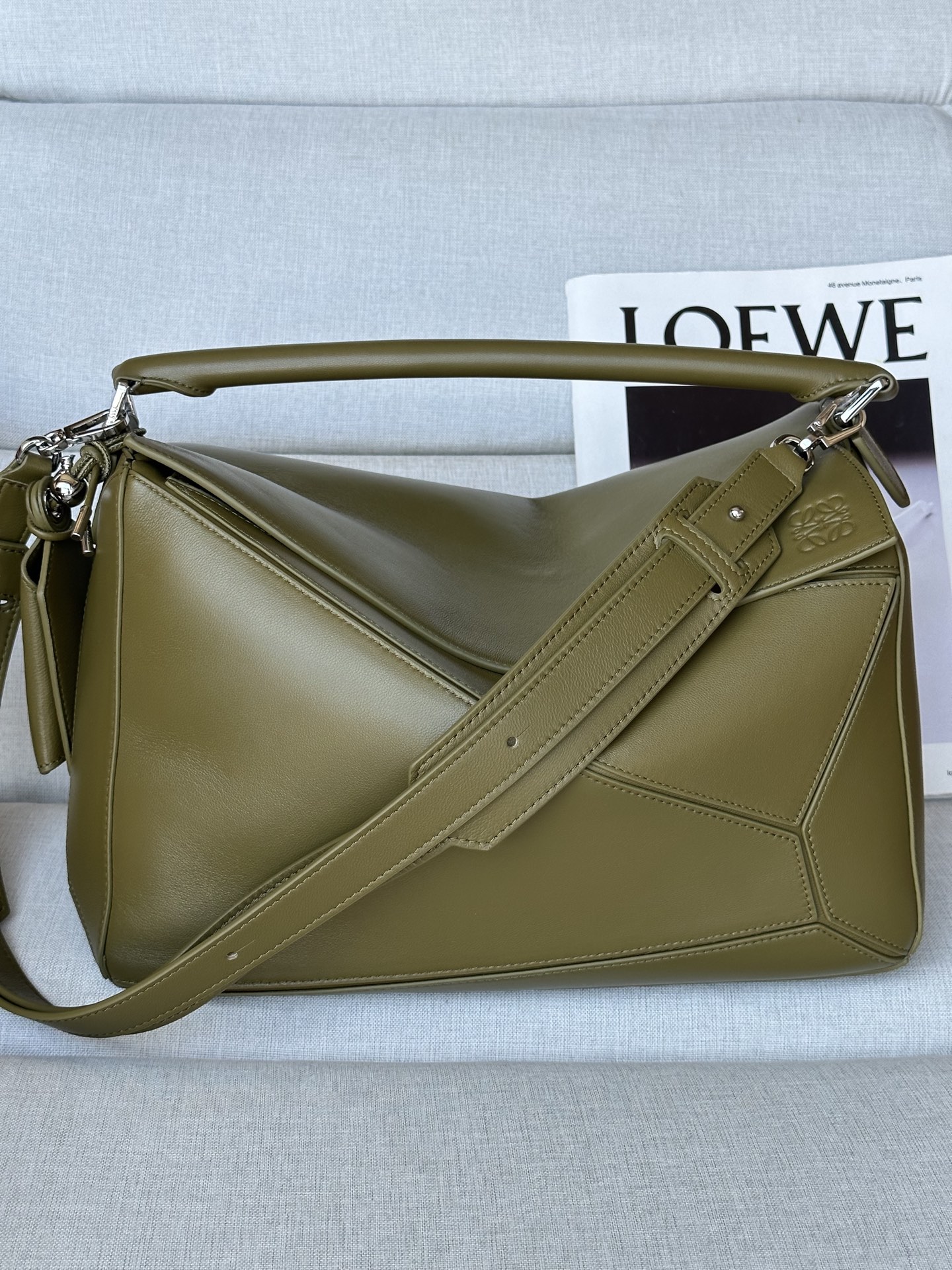 NO:341195,Extra grade Olive Green Large Napa Sheep Leather Featherlight Puzzle Handbag Size 33-21- Model 3006 Featherlight Puzzle outlines the rectangular shape with unique geometric lines. Soft and lightweight Napa leather injects casual and lazy style into the bag. Shoulder, crossbody or carry Removable adjustable shoulder straps with rotary snaps Zip closure, articulated zipper head One external zipper rear pocket, two internal insert pockets Removable LOEWE gold or silver label with secret pockets and balloon dice Rectangular metal foot nails Napa Sheep Leather lining Anagram embossed, engraved inside the decorative LOEWE Size: 33*14.7*21.5cm, special grade Luo Yiwei, loewe, loewe, sheepskin19860909特级 橄欖綠色 大号纳帕羊皮革 Featherlight Puzzle 手袋 尺寸33-21- 型号3006  Featherlight Puzzle 以别具一格的几何线条勾勒长方体造型.柔软轻盈的纳帕皮革为手袋注入随性慵懒的风格. 可肩背、斜挎或手提 可拆卸可调节肩带,饰有旋转卡扣 拉链开合,铰接式拉链头 一个外部拉链后袋,两个内部插袋 可拆卸 LOEWE 烫金或烫银标签,饰有隐秘口袋和气球骰子 长方形金属脚钉 纳帕羊皮革衬里 Anagram 压纹、饰牌内部镌刻 LOEWE 字样 尺寸:33*14.7*21.5cm,特级罗意威,loewe,loewe,sheepskin,Bag