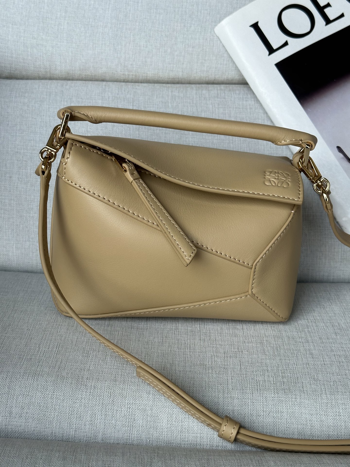 NO:341161,Super mini beige handbag Latest version adjustable shoulder straps Lo*we debuts debut handbag* rectangular shape and precise cutting technology create Puzzle unique geometric lines* This mini version is made of satin cowhide leather with cage stitching edges Mini Puzzle can hold for example a small vertical wallet, most sizes of phones (up to 6.1 inches) and sunglasses case, shoulder or crossbody* adjustable shoulder straps, removable*zipper closure,*cock leather zipper head*herring cotton canvas lining Anagram embossed size:18*12.5*8CＭ Model 3000b, super Loewe, wallets, cowhide19860909特级 mini 米黄 手袋 最新版本肩带可调节 Lo*we推出的首次亮相手提包*长方体形状和精确的切割技术创造了 Puzzle 独特的几何线条*这个迷你版本采用缎面牛皮革制成,带有笼盖缝线边缘 迷你Puzzle可以容纳例如一只小号垂直钱包、大多数尺寸的手机（最大6.1英寸）和太阳镜盒,肩背或斜挎*肩带可调节,可拆卸*拉链封口,*牛皮革拉链头*人字纹棉质帆布衬里Anagram 压纹 size:18*12.5*8CＭ 型号3000b,特级罗意威,loewe,wallets,cowhide,Bag