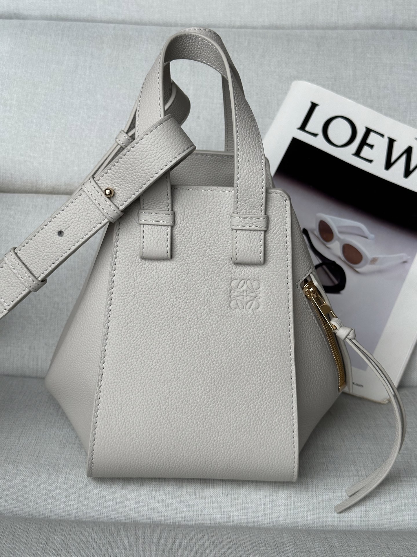 NO:341151,Extra Loewe hammock compact version. Light gray between mini and small Model 8047 compaet version New size 20-19-14 Hammock is a multi-purpose handbag with soft side bread that releases the sides to change shape. The loop strap allows the handbag to be worn in a variety of ways. This new compact version is made of soft grain cowhide leather Crossbody, shoulder back or carried through top handle Removable, adjustable shoulder strap Internal hook closure Two internal insert pockets, one external zipper pocket Customizable with shoulder straps and personalized hanging Herringbone cotton canvas lining Anagram embossed, loewe, loewe, cowhide19860909特级 loewe hammock紧凑版本. 輕灵灰 介于mini跟小号中间 型号8047 compaet珍版本 新尺寸20-19-14 Hammock 是一款带有柔软侧面包身的多功能手袋,可释放侧面来改变形状. 环状带子可以使手袋有多种佩戴方式. 这个全新的紧凑版本采用柔软粒面牛皮革制成 斜挎,肩背或通过顶部提手携带 可拆卸,可调节肩带 内部钩扣封口 两个内部插袋,一个外部拉链口袋 可以使用肩带和个性化挂饰进行定制 人字纹棉帆布衬里 Anagram 压纹,特级罗意威,loewe,loewe,cowhide,Bag