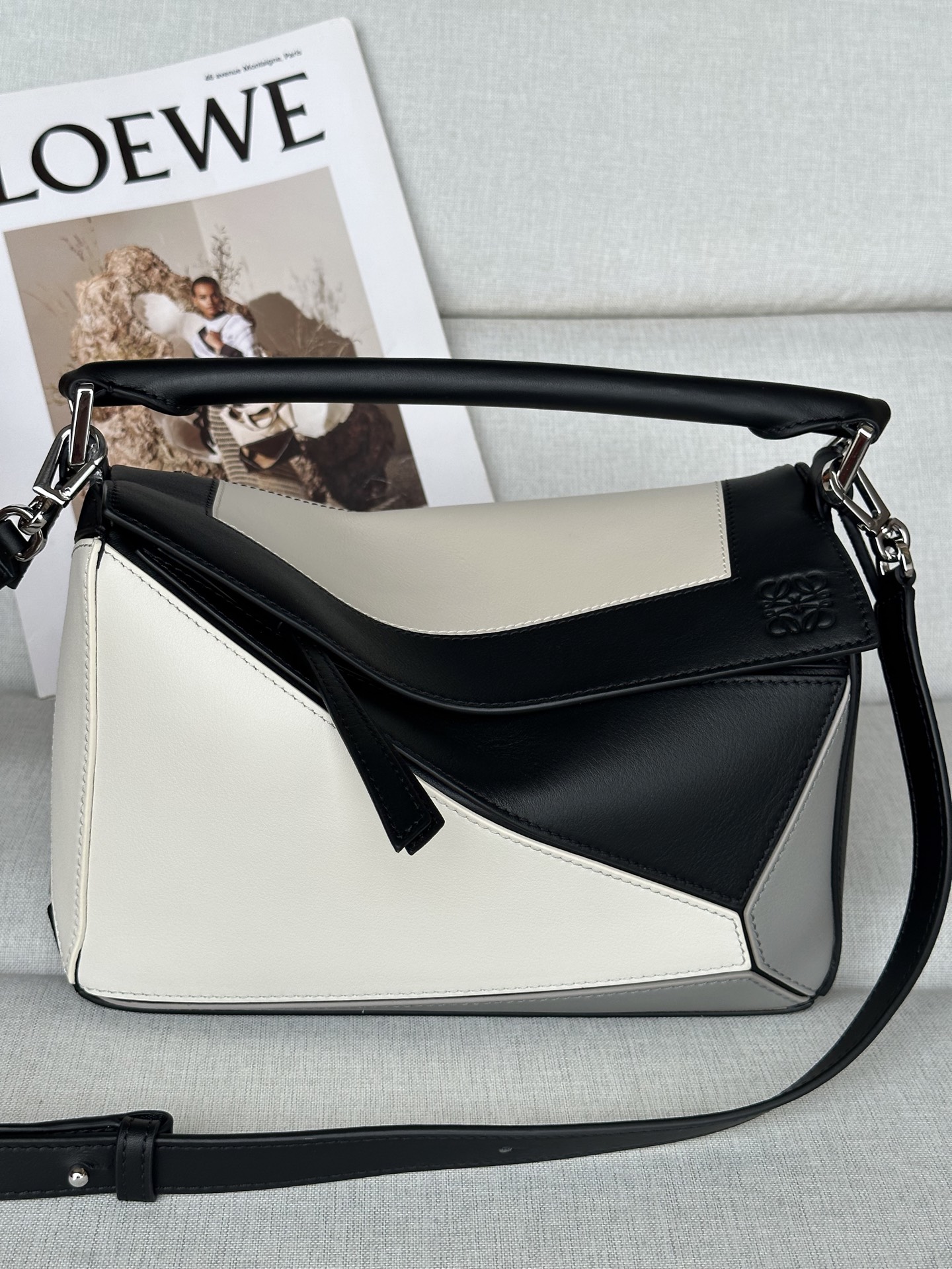 NO:574103,The premium Puzzle outlines a rectangular shape with distinctive geometric lines. This small version is made of Nappa cow leather with a square intarsia pattern inspired by Josef Albers' 'Homage to the Square' series. This bag is part of the LOEWE x Josef and Anni Albers collection. Model 3001-1 0. Can be worn on the shoulder, crossbody or handbag Detachable and adjustable shoulder strap Zipper closure, cowhide zipper puller One external zipped back pocket, one internal slip pocket Suede lining Anagram embossed, LOEWE hot stamping and Josef Albers signature Main material Nappa cow leather Strap length 80.5 - .5 cm Handle drop 7 cm Weight 0.5205 kg Height 16.5 cm Width 24 cm Depth 10.5 Centimeter, special grade Loewe, loewe, loewe, cowhide19860909特级 Puzzle 以别具一格的几何线条勾勒长方体造型. 此小号版本采用纳帕牛皮革制成,方形嵌花图案的灵感源自 Josef Albers 的 “Homage to the Square” 系列.这款手袋为 LOEWE x Josef and Anni Albers 系列作品. 型號3001-1 0. 可肩背、斜挎或手提 可拆卸可调节肩带 拉链开合,牛皮革拉链头 一个外部拉链后袋,一个内部插袋 绒面革衬里 Anagram 压纹、LOEWE 烫金和 Josef Albers 签名 Main material 纳帕牛皮革 Strap length 80.5 - .5 cm 肩带长度 40 - 58 cm Handle drop 7 cm Weight 0.5205 kg Height 16.5 公分 Width 24 公分 Depth 10.5 公分,特级罗意威,loewe,loewe,cowhide,Bag