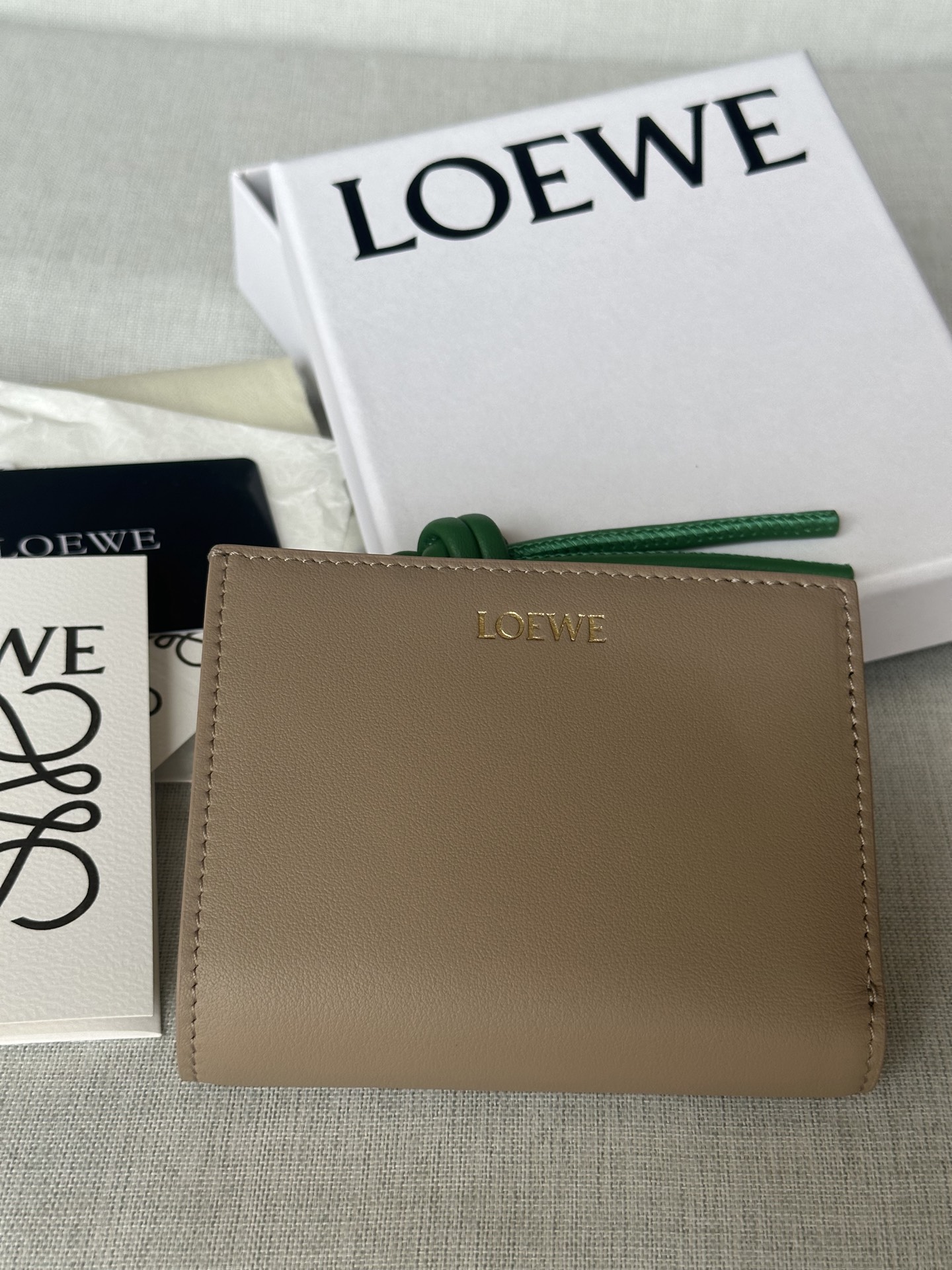 NO:580677,Premium ready stock glossy nappa calfskin short leather wallet with knotted zippers. Model 11.5-8.5, super Loewe, loewe, loewe, cowhide19860909特级 现货 亮面納帕小牛皮繩結短皮夾 型號X1 沙色 亮面納帕小牛皮短皮夾,對比色繩結拉鍊頭. 六個置卡夾,三個內部插袋 一個拉鍊硬幣隔層,小牛皮拉鍊頭 按扣 對比色小牛皮內裡 LOEWE 燙金 公分·in 顏色 棕褐色/木瓜色 金屬色 金色 材質 亮面納帕小牛皮 11.5-8.5,特级罗意威,loewe,loewe,cowhide,Bag