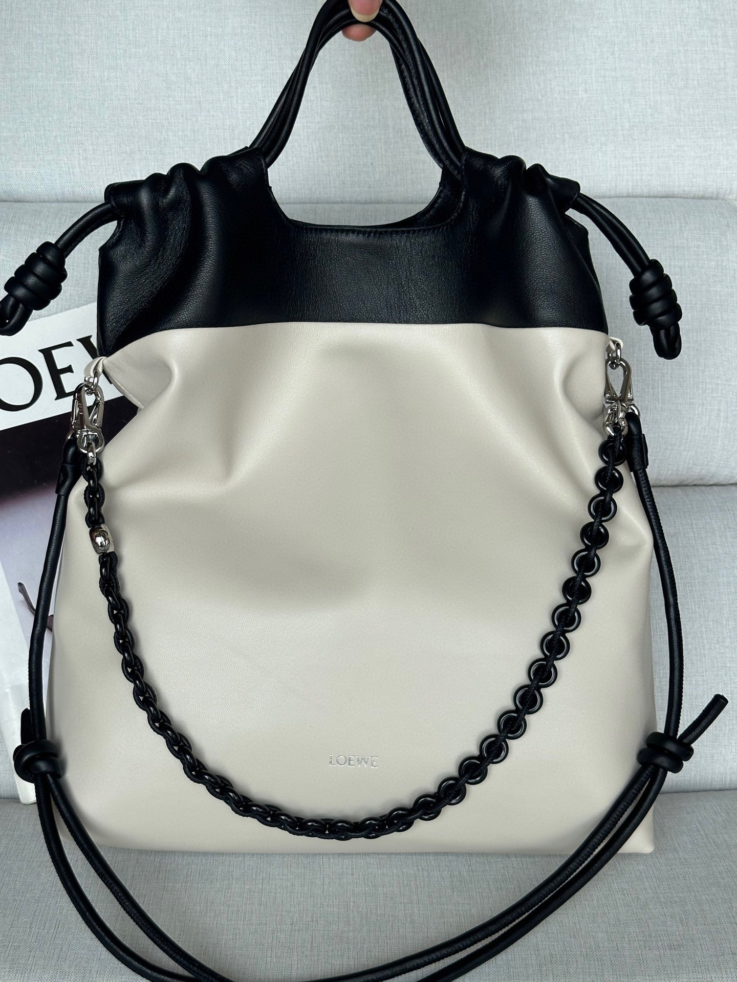 NO:580679,Special Model Soft Nappa Lambskin Flamenco Purse Tote The Flamenco Purse Tote is a soft, practical bag with a straight design, a time-honored drawstring knot and a tonal donut chain with a contrasting top. This version is made from soft nappa lambskin. Can be worn on the shoulder, crossbody or by hand Top handle, adjustable and removable leather strap Detachable donut chain embellished Anagram Pebble magnetic closure Suede lining Hot stamping or silver LOEWE two-tone soft nappa lambskin Shoulder strap length 61 / 73 - 126 cm Shoulder strap length 25 / 30 - 57 cm Handle height 7 cm 38-29-9, premium Loewe, loewe, loewe, totes, sheepskin, chamois leather19860909特级 型號 柔軟納帕小羊皮 Flamenco Purse 托特包 Flamenco Purse 托特包是柔軟實用的包款,採用直式設計、歷史悠久的抽繩繩結和與對比色頂部搭配的同色系甜甜圈鍊帶.此版本以柔軟納帕小羊皮製成. 可肩背、斜背或手提 頂部手提把,皮革肩帶可調整拆卸 可拆式甜甜圈鍊帶裝飾 Anagram Pebble 磁扣 麂皮內裡 燙金或燙銀 LOEWE 雙色柔軟納帕小羊皮 肩背帶長度 61 / 73 - 126 cm 肩帶長度 25 / 30 - 57 cm 把手高度 7 cm 38-29-9,特级罗意威,loewe,loewe,totes,sheepskin,chamois leather,Bag