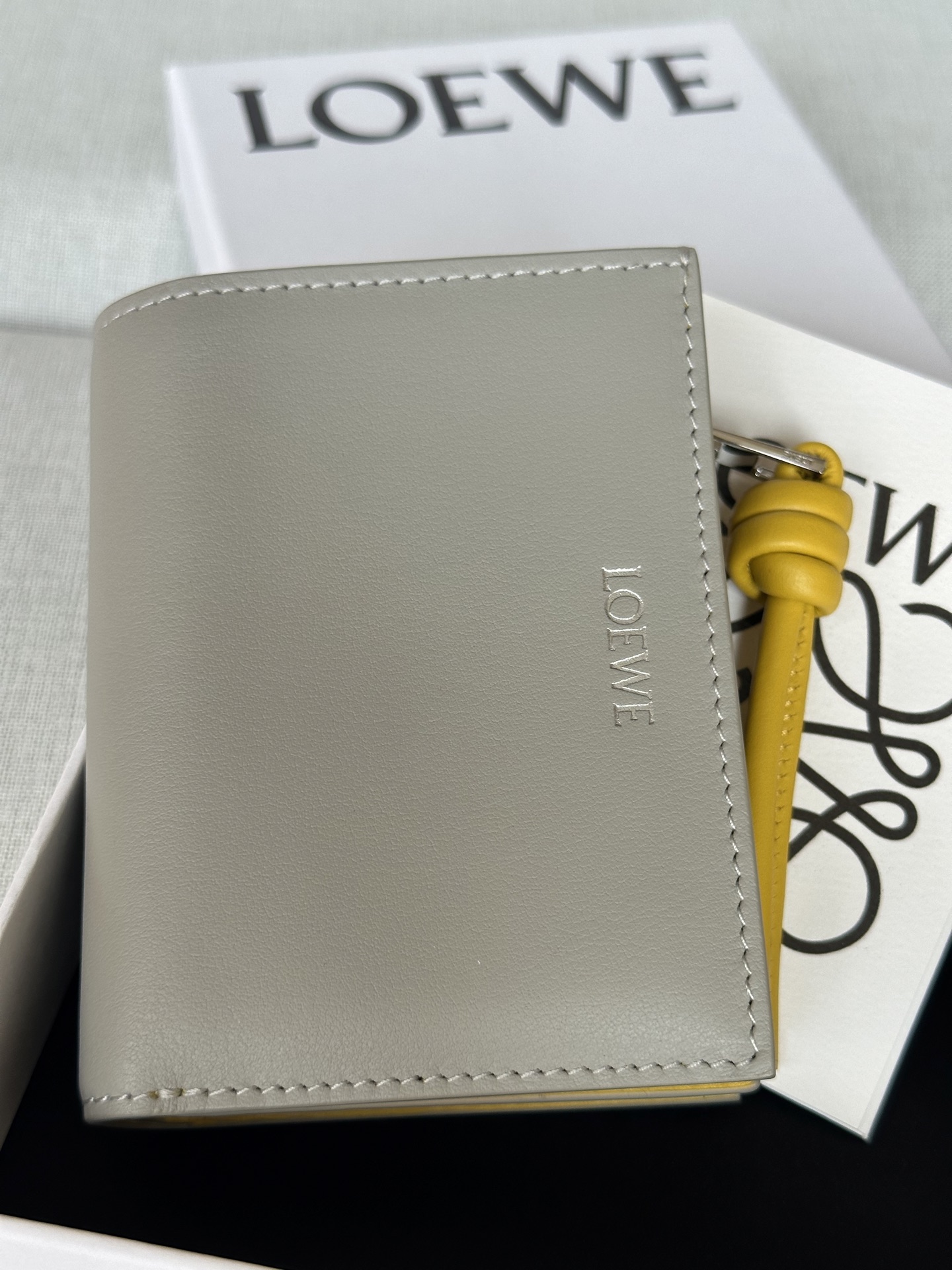 NO:580673,Special grade ready-made glossy nappa calfskin short leather wallet with knots. Model 11.5-8.5, super Loewe, loewe, loewe, cowhide19860909特级 现货亮面納帕小牛皮繩結短皮夾 型號X1 贝壳灰 亮面納帕小牛皮短皮夾,對比色繩結拉鍊頭. 六個置卡夾,三個內部插袋 一個拉鍊硬幣隔層,小牛皮拉鍊頭 按扣 對比色小牛皮內裡 LOEWE 燙金 亮面納帕小牛皮 11.5-8.5,特级罗意威,loewe,loewe,cowhide,Bag
