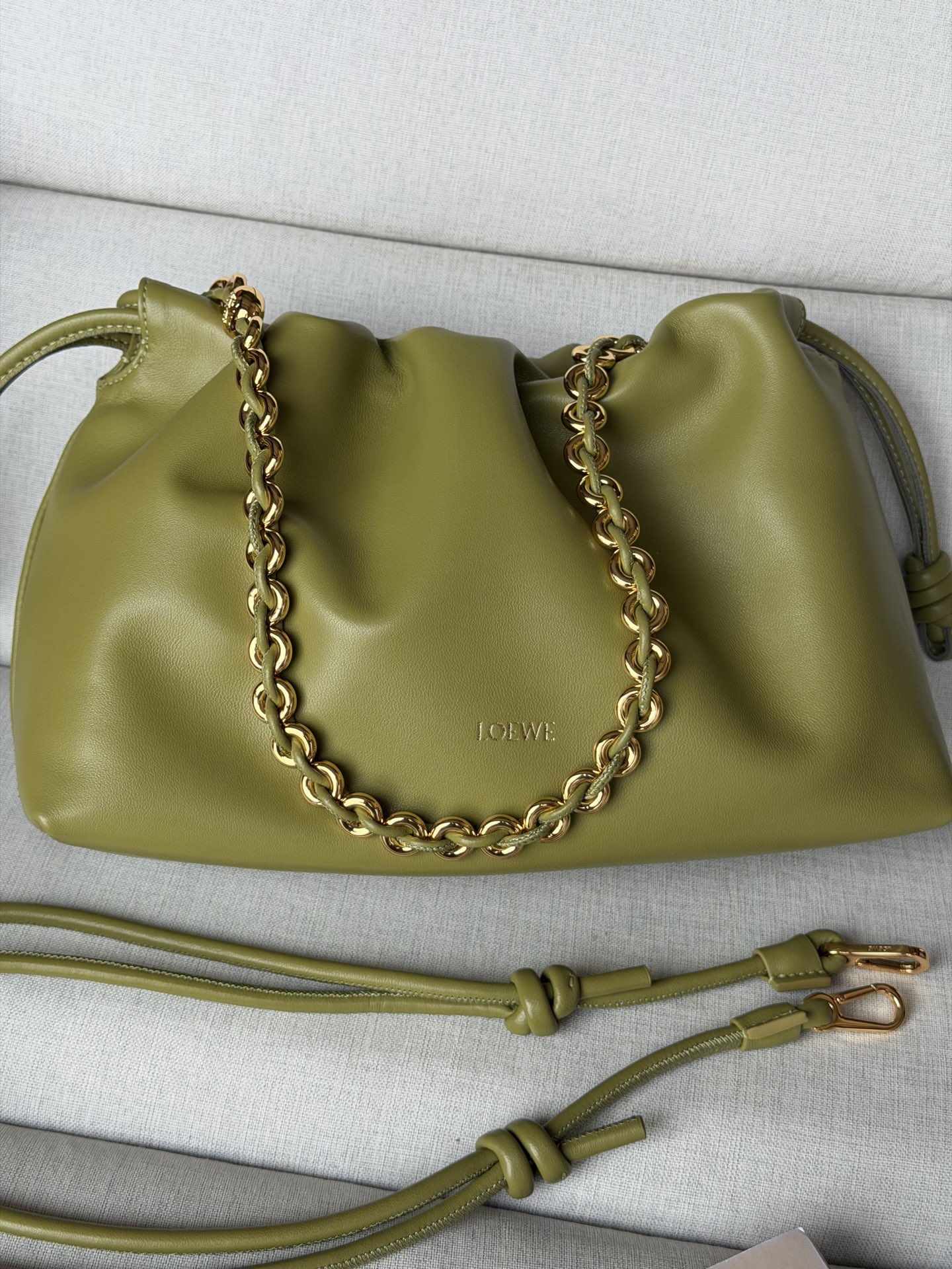 NO:580683,Special Grade 1774 (matching metal chain + 1 long shoulder strap) Light Moss Color Soft Nappa Lamb Leather Flamenco Purse Clutch Large Size 30-10.5-20 The Flamenco Purse handbag has a pleated design and key details such as the signature knot on the side. The style is fashionable and versatile and can be carried as a clutch bag, worn on the shoulder with a donut chain, or worn cross-body with a leather shoulder strap. This version is made of soft Nappa sheep leather. Can be worn on the shoulder, crossbody or handheld Detachable and adjustable leather shoulder strap Detachable donut chain decorated with Anagram engraved pebbles Discreet magnetic closure Suede lining LOEWE hot stamping or silver, premium Loewe, loewe, loewe, handbag, sheepskin19860909特级 1774（配套金屬鏈條+1條長肩帶） 浅苔藓色 柔软纳帕羊皮革 Flamenco Purse 手拿包 大號30-10.5-20 Flamenco Purse 手袋采用褶皱设计,侧面搭配标志性绳结等关键细节.款式时尚百搭,可作为手拿包携带,亦可搭配甜甜圈链条肩背,或搭配皮革肩带斜挎.此版本采用柔软纳帕羊皮革制成. 可肩背、斜挎或手提 可拆卸可调节皮革肩带 可拆卸甜甜圈链条饰有Anagram 镌刻卵石纹 低调的磁扣开合 绒面革衬里 LOEWE烫金或烫银,特级罗意威,loewe,loewe,handbag,sheepskin,Bag