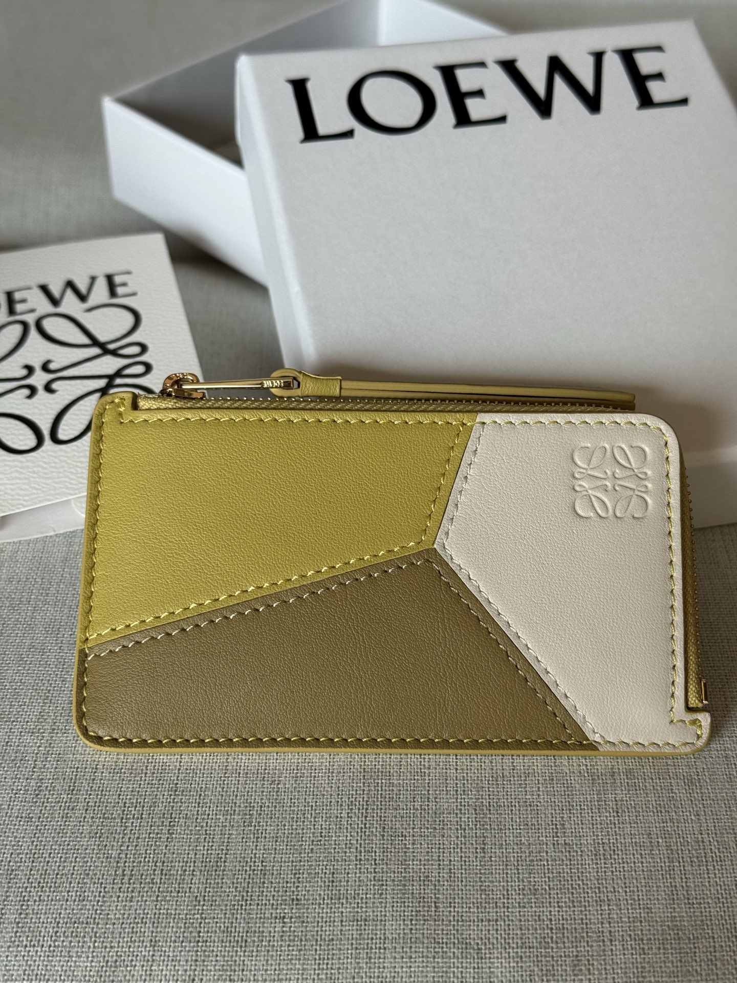 NO:670892,Premium Original Leather Classic Cow Leather Puzzle Coin Card Holder A03-1 Turmeric White This coin card holder is inspired by the Puzzle bag and features a unique geometric pattern. This version is crafted in contrasting classic cow leather. Four card slots One zipped coin compartment, cow leather zip puller Cow leather lining Anagram embossed cm in Metallic color Gold Main material Classic cow leather Weight 0.04 kg Height 7.5 cm  Width 13 cm Depth 1 cm, premium Loewe, loewe, cowhide19860909特级 原厂皮 经典牛皮革 Puzzle 硬币卡包 A03-1 姜黄拼白 这款硬币卡包的灵感来自 Puzzle 手袋,采用独特的几何图案.此版本采用对比色经典牛皮革制成. 四个卡位 一个拉链硬币隔层,牛皮革拉链头 牛皮革衬里 Anagram 压纹 公分·in Metallic colour 金色 Main material 经典牛皮革 Weight 0.04 kg Height 7.5 公分 Width 13 公分 Depth 1 公分,特级罗意威,loewe,cowhide,Bag