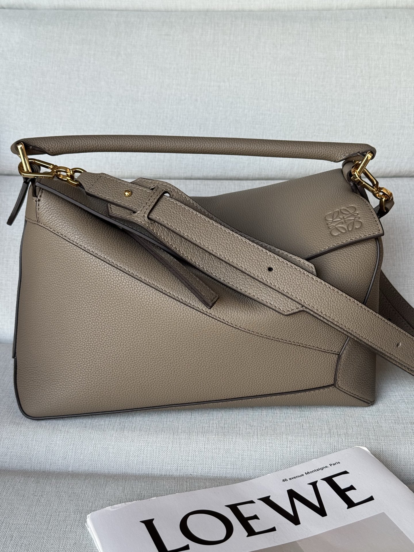 NO:670884,Premium original leather 3002b light taupe Puzzle handbag. The medium 29cm Puzzle handbag is the first handbag launched by creative director Jonathan Anderson for LOEWE. The rectangular shape and precise cutting technology create the unique geometric lines of the Puzzle. This version is made of grained calfskin and decorated with overlapping edges. Can be worn on the shoulder, cross-body or hand-held. Detachable and adjustable shoulder strap  Two interior slip pockets and one exterior rear zip pocket Herringbone cotton canvas lining Anagram embossed, premium Loewe, loewe, cowhide19860909特级 原厂皮 3002b浅灰褐色 Puzzle 手袋 . 中号29cm Puzzle 手袋是创意总监乔纳森·安德森（Jonathan Anderson）为 LOEWE 推出的首款手提包.长方体形状和精确的切割技术创造了 Puzzle 独特的几何线条.此版本采用粒面牛皮革打造,饰有重叠边缘. 可肩背、斜背或手提 可拆卸可调节肩带 两个内部插袋和一个外部后方拉链袋 人字纹棉质帆布衬里 Anagram 压纹,特级罗意威,loewe,loewe,cowhide,Bag