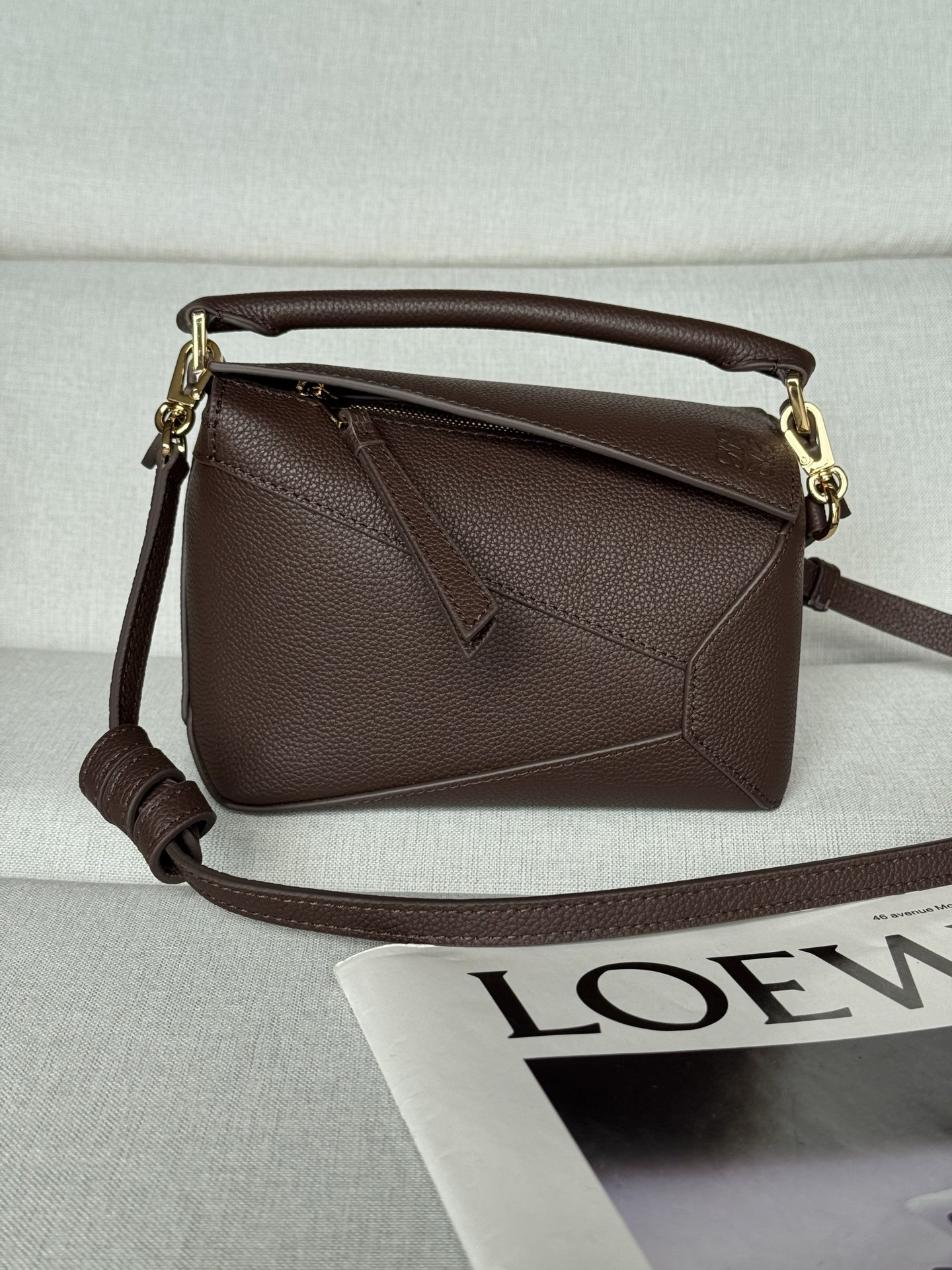 NO:670870,Premium Original Leather Puzzle Edge Brownie Bag Latest version with adjustable shoulder strap Debut handbag from Lo*we* The rectangular shape and precise cutting techniques create the unique geometric lines of the Puzzle* This mini version is crafted from satin cow leather with caged stitching edges  Mini Puzzle can hold, for example, a small vertical wallet, most cell phone sizes (up to 6.1 inches) and sunglasses case, carried over the shoulder or across the body*Adjustable shoulder strap, removable*Zip closure,*Cow leather zipper pull*Herringbone cotton canvas liningAnagram embossed size: 18*12.5*8CM Model 3000m, Premium Loewe,thom browne,loewe,wallets,cowhide19860909特级 原厂皮 Puzzle Edge 荔布朗尼棕 手袋 最新版本肩带可调节 Lo*we推出的首次亮相手提包*长方体形状和精确的切割技术创造了 Puzzle 独特的几何线条*这个迷你版本采用缎面牛皮革制成,带有笼盖缝线边缘 迷你Puzzle可以容纳例如一只小号垂直钱包、大多数尺寸的手机（最大6.1英寸）和太阳镜盒,肩背或斜挎*肩带可调节,可拆卸*拉链封口,*牛皮革拉链头*人字纹棉质帆布衬里Anagram 压纹 size:18*12.5*8CＭ 型号3000m,特级罗意威,thom browne,loewe,wallets,cowhide,Bag