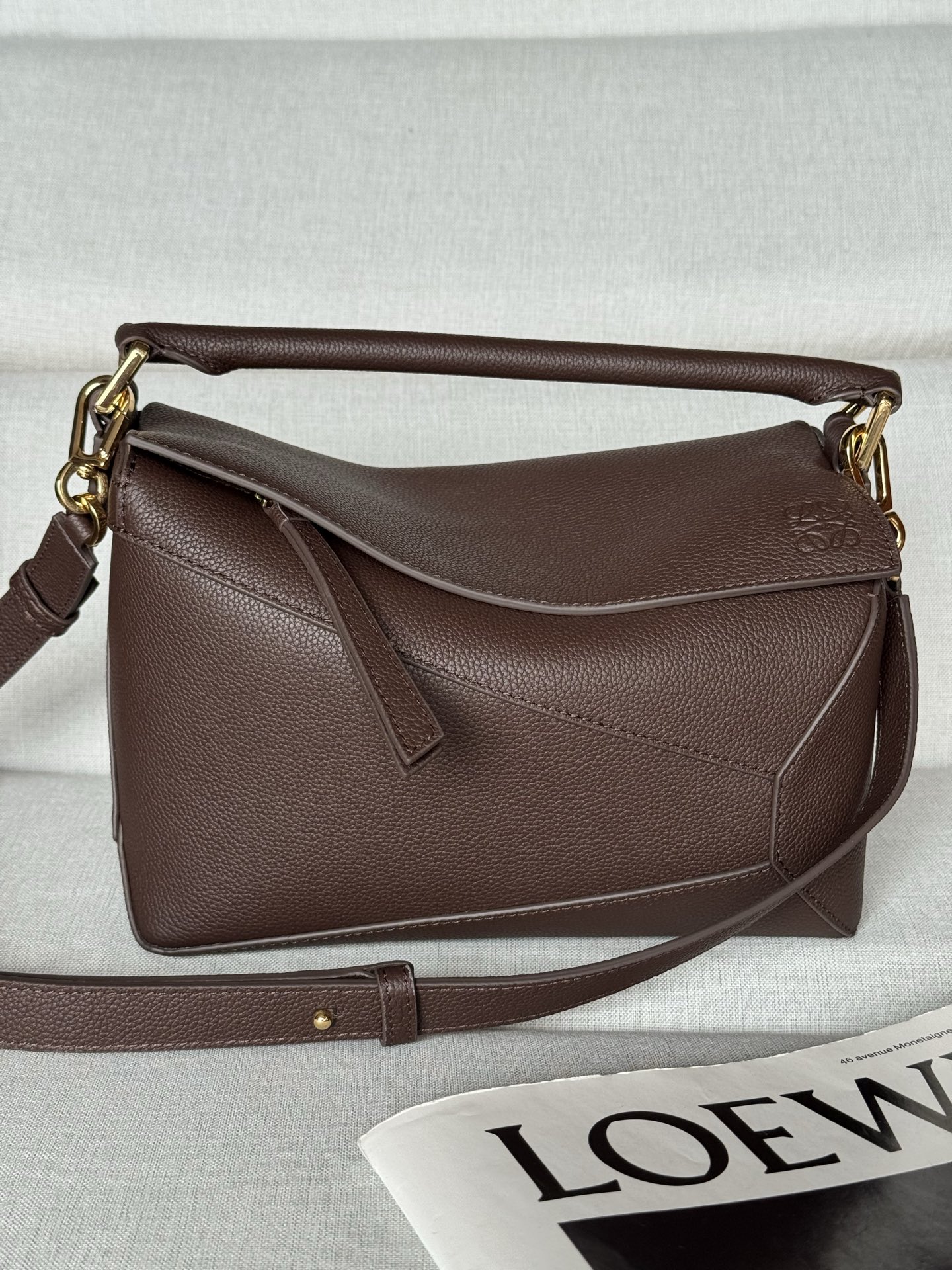 NO:670872,Premium Original Leather 3001m Brownie Brown Puzzle Small 24cm The Puzzle bag is the first handbag launched by Creative Director Jonathan Anderson for LOEWE. The rectangular shape and precise cutting technology create the unique geometric lines of the Puzzle. This version is made of grained calfskin with overlapping edges. Can be worn on the shoulder, cross-body or handheld Detachable and adjustable shoulder strap  Two interior slip pockets and one exterior rear zip pocket Herringbone cotton canvas lining Anagram embossed, premium Loewe, Thom Browne, Loewe, Loewe, Cowhide19860909特级 原厂皮 3001m 荔布朗尼棕 Puzzle 小号24cm Puzzle 手袋是创意总监乔纳森·安德森（Jonathan Anderson）为 LOEWE 推出的首款手提包.长方体形状和精确的切割技术创造了 Puzzle 独特的几何线条.此版本采用粒面牛皮革打造,饰有重叠边缘. 可肩背、斜背或手提 可拆卸可调节肩带 两个内部插袋和一个外部后方拉链袋 人字纹棉质帆布衬里 Anagram 压纹,特级罗意威,thom browne,loewe,loewe,cowhide,Bag