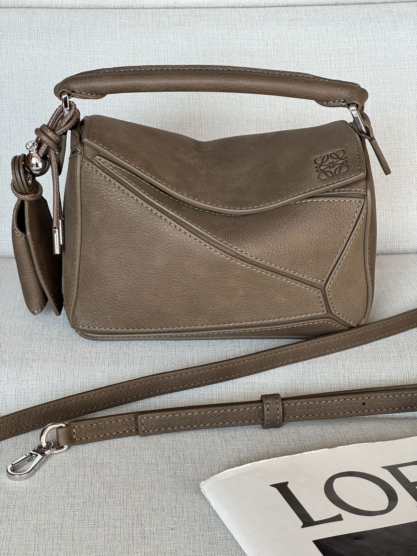 NO:718101,Premium original leather mini nubuck leather Puzzle handbag 18cm Model-1 Featherlight Puzzle outlines a rectangular shape with unique geometric lines. The soft and lightweight Nappa leather injects a casual and lazy style into the handbag. Can be carried on the shoulder, crossbody or handheld Detachable and adjustable shoulder strap decorated with rotating buckle, top handle Zipper closure, hinged zipper puller Detachable LOEWE  Hot stamping or silvering label, decorated with secret pockets and balloon dice Rectangular metal feet Nappa sheep leather lining Anagram embossed, plaque engraved on the inside LOEWE Size: 17.5*7.5*12.5cm, premium LOEWE, loewe, loewe, sheepskin19860909特级 原厂皮 迷你牛巴革 Puzzle 手袋 18cm 型号-1 Featherlight Puzzle 以别具一格的几何线条勾勒长方体造型.柔软轻盈的纳帕皮革为手袋注入随性慵懒的风格. 可肩背、斜挎或手提 可拆卸可调节肩带饰有旋转卡扣,顶部提手 拉链开合,铰接式拉链头 可拆卸 LOEWE 烫金或烫银标签,饰有隐秘口袋和气球骰子 长方形金属脚钉 纳帕羊皮革衬里 Anagram 压纹、饰牌内侧刻有 LOEWE 尺寸:17.5*7.5*12.5cm,特级罗意威,loewe,loewe,sheepskin,Bag