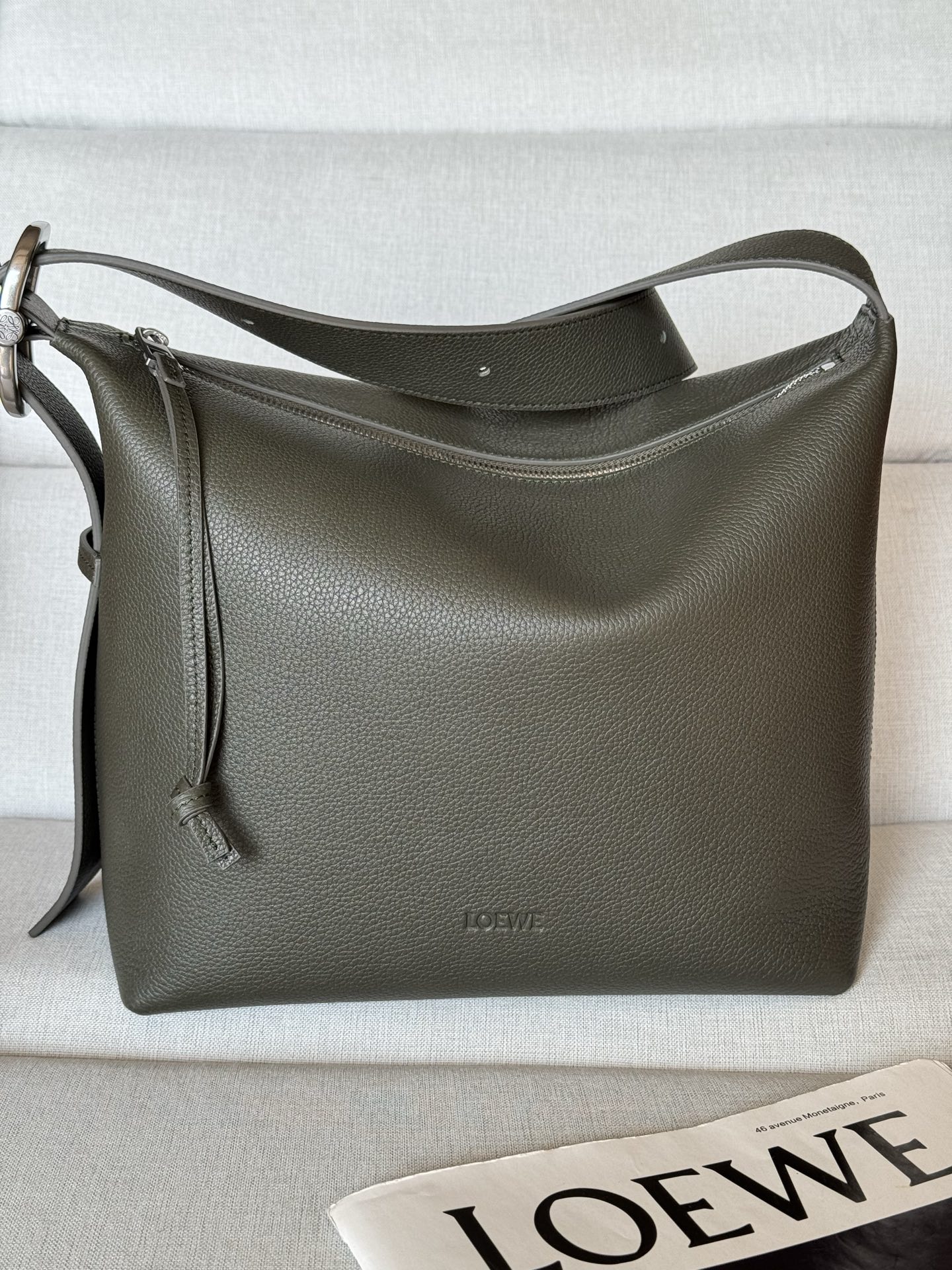 NO:812439,Premium soft grained cowhide Loop Hobo Bag 337 Khaki Green The Loop Hobo bag has a soft, streamlined shape that molds smoothly to your body. The straps can be adjusted with the signature buckle for flexibility. This version is made from soft grained cowhide. Can be worn on the shoulder or cross-body Adjustable shoulder strap Zip closure One internal patch pocket Fabric lining LOEWE embossed cm·in 26-24-13cm  Color Dark khaki green Metallic color Palladium gold Main material Soft grained cow leather Strap length 69 - 102 cm Shoulder strap length 30 - 48 cm, premium Loewe, loewe, loewe, cowhide19860909特级 柔软粒面牛皮革 Loop Hobo 手袋 337 卡其绿色 Loop Hobo 手袋呈现柔软的流线型,可流畅贴合体形.环带可通过标志性搭扣进行调整,灵活多变.此版本采用柔软粒面牛皮革制成. 可肩背或斜挎 可调节肩带 拉链开合 一个内部贴袋 织物衬里 LOEWE 压纹 公分·in 26-24-13cm Colour 深卡其绿 Metallic colour 钯金色 Main material 柔软粒面牛皮革 Strap length 69 - 102 cm 肩带长度 30 - 48 cm,特级罗意威,loewe,loewe,cowhide,Bag