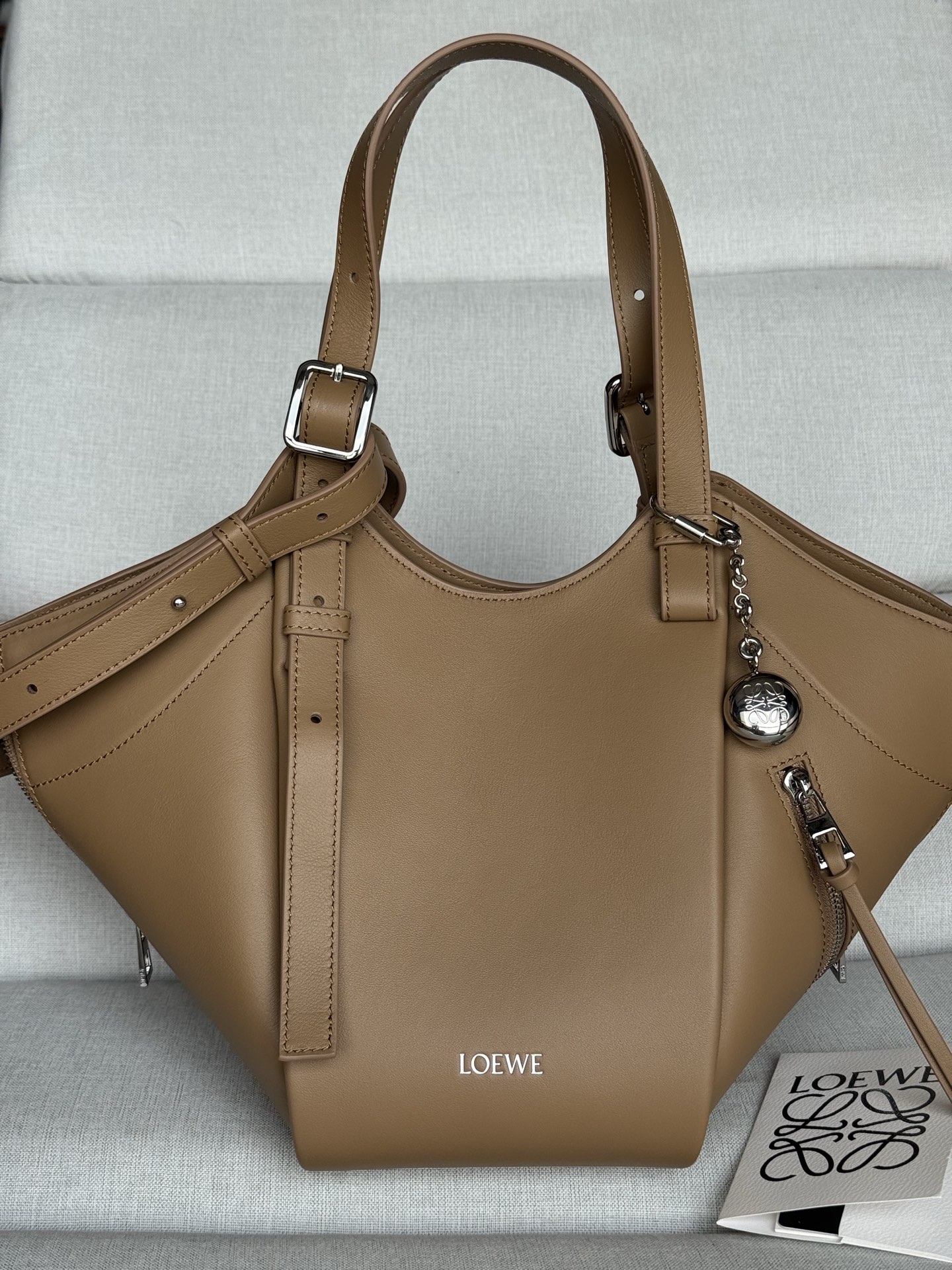 NO:812501,Premium Classic Cow Leather Hammock Flip Handbag Model 33705 Mocha Hammock Flip Handbag interprets the classic bag with soft texture and practical function, while continuing the iconic details of the series. It uses a creative stitching and flip structure to easily convert between a shoulder bag and a close-fitting Hobo handbag. This version is made of classic cow leather. Can be worn on the shoulder, cross-body or handbag Detachable and adjustable shoulder strap Magnetic closure  One exterior zip pocket, two interior slip pockets Herringbone cotton canvas lining LOEWE hot stamping or silver foil Size 15-22-21., Premium Loewe, loewe, loewe, backpacks, cowhide19860909特级 经典牛皮革 Hammock Flip 手袋 型号33705 摩卡色 Hammock Flip 手袋以柔软质感与实用功能诠释经典包款,同时延续该系列的标志性细节.采用颇具创意的缝合和翻转结构,可于肩背包和贴身 Hobo 手袋之间轻松转换.此版本采用经典牛皮革制成. 可肩背、斜挎或手提 可拆卸可调节肩带 磁扣开合 一个外部拉链口袋,两个内部插袋 人字纹棉质帆布衬里 LOEWE 烫金或烫银 尺寸15-22-21 .,特级罗意威,loewe,loewe,backpacks,cowhide,Bag