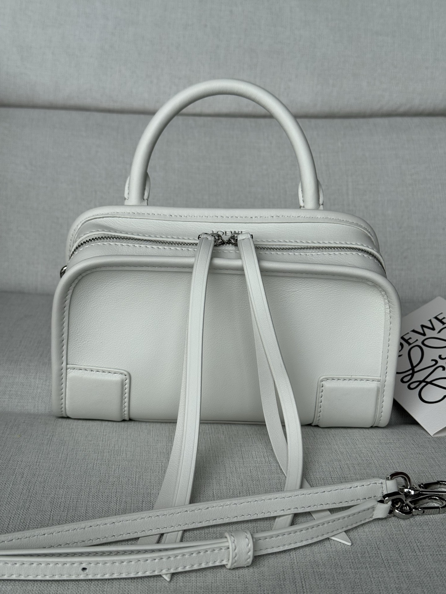 NO:812476,Special Model 1579 Size 18-11-7.5 Mini soft calf leather Amazona Amazona reinterprets LOEWE's legendary handbag in a casual silhouette with a single top handle. The bag has an open design and the main compartment is secured with a hidden buckle. Comes with a detachable shoulder and crossbody strap for a practical style. This mini version is made of soft calf leather. .Two carrying methods, short handle, detachable and adjustable crossbody strap  .Zipper with two leather zipper pulls .Two compartments, main compartment closed with magnetic buckle .D-ring on left side can be customized .Suede lining .LOEWE hot stamping or silver, Double L embossed brand logo, premium LOEWE, loewe, loewe, cowhide19860909特级 型号1579 尺寸18-11-7.5 迷你柔软牛皮革Amazona Amazona重新诠释LOEWE传奇手袋,呈现休闲廓形,搭配单一顶部提手.手袋采用开放式设计,主隔层以隐藏扣固定.搭配可拆卸肩背和斜挎背带,打造实用风格.此迷你版本采用柔软牛皮革制成. .两种携带方式短提手,可拆卸可调整的斜挎肩带 .拉链配有两个皮革拉链头 .两个隔层,主隔层以磁扣开合 .左侧D形环可定制 .绒面革衬里 .LOEWE烫金或烫银,Double L压纹品牌标志,特级罗意威,loewe,loewe,cowhide,Bag