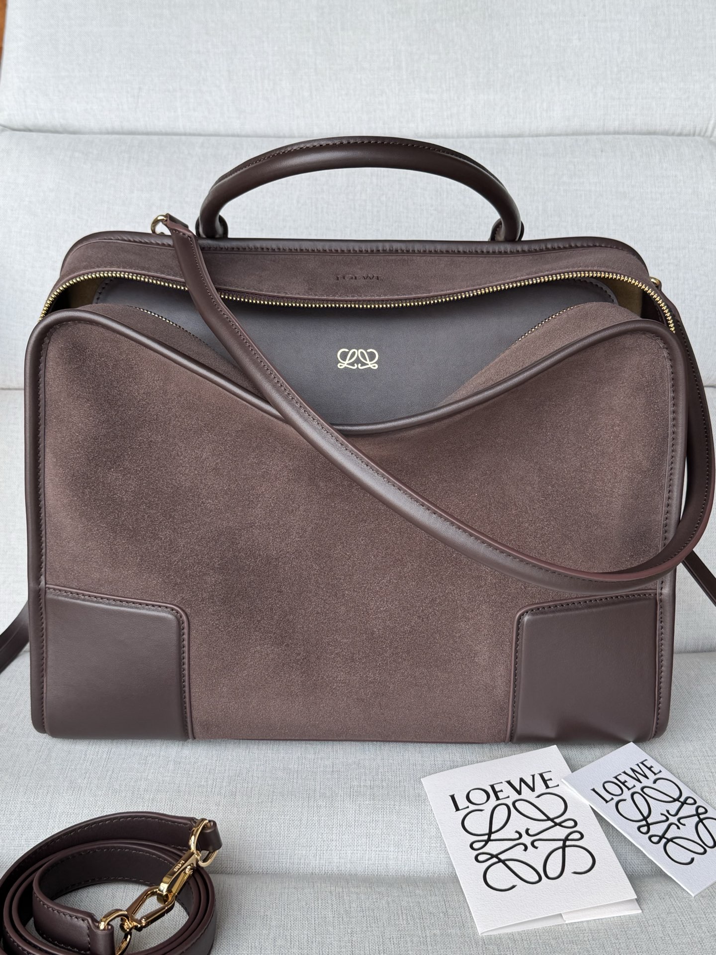 NO:812449,Special Model 1581 35-24-16cm Large Suede Amazona Bag The Amazona reinterprets the legendary LOEWE bag in a relaxed silhouette with a single top handle. The bag has an open design and the main compartment is secured with a hidden buckle. Comes with a detachable shoulder and cross-body strap for a practical style. This large version is made of suede. Three ways to carry: short handle, detachable shoulder and cross-body strap  Zipper with two leather zip pulls Two compartments, main compartment closed with magnetic snap Internal flat pocket D-ring on the left for customization Suede and nappa sheepskin lining LOEWE hot stamping or silver, Double L embossed brand logo cm in Color Dark maroon Metallic color Gold Main material Suede/Cow leather Strap length 108 cm Shoulder strap length 50 cm Handle drop 10 - 23  cm,Super Loewe,loewe,loewe,cowhide,sheepskin19860909特级 型号1581 35-24-16cm 大号绒面革 Amazona 手袋 Amazona 重新诠释 LOEWE 传奇手袋,呈现休闲廓形,搭配单一顶部提手.手袋采用开放式设计,主隔层以隐藏扣固定.搭配可拆卸肩背和斜挎背带,打造实用风格.此大号版本采用绒面革制成. 三种携带方式短提手、可拆卸肩背和斜挎背带 拉链配有两个皮革拉链头 两个隔层,主隔层以磁扣开合 内部扁平口袋 左侧 D 形环可定制 绒面革和纳帕羊皮革衬里 LOEWE 烫金或烫银,Double L 压纹品牌标志 公分·in Colour 深栗色 Metallic colour 金色 Main material 绒面革/牛皮革 Strap length 108 cm 肩带长度 50 cm Handle drop 10 - 23 cm,特级罗意威,loewe,loewe,cowhide,sheepskin,Bag