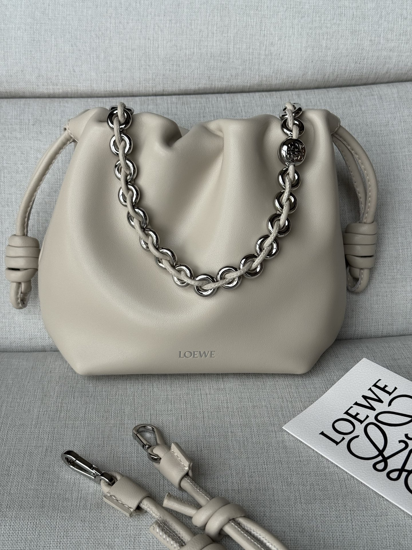NO:812473,Special grade new product soft white model 1773 23-17-5.5 (matching metal chain and extended leather shoulder strap) mini nappa sheep leather Flamenco clutch. The Flamenco clutch released in the 1870s is tightened with a drawstring and tied with the iconic coiled knot. Flamenco Purse Cleverly redesigned, it features slim knots and a pleated top for a soft, sensual drape. This version is crafted from supple nappa sheepskin. Can be worn cross-body or over the shoulder Detachable, adjustable shoulder strap Discreet magnetic closure Suede lining Material: Sheepskin Weight: 0.2 kg, Premium Loewe, loewe, handbag, sheepskin19860909特级 新品 柔白色 型號1773 23-17-5.5(配套金屬鏈條加长皮肩帶） 迷你纳帕羊皮革 Flamenco 手拿包 十九世纪七十年代发布的 Flamenco 手拿包,采用拉绳收紧,并打上标志性的盘绕结.Flamenco Purse 经过巧妙的重新设计,以纤巧的绳结和褶皱顶部打造柔软感性的垂坠设计.此版本采用柔软纳帕羊皮革制成. 可斜挎或肩背 可拆卸可调节肩带 低调的磁扣开合 绒面革衬里 材质:羊皮革 重量:0.2 kg,特级罗意威,loewe,handbag,sheepskin,Bag