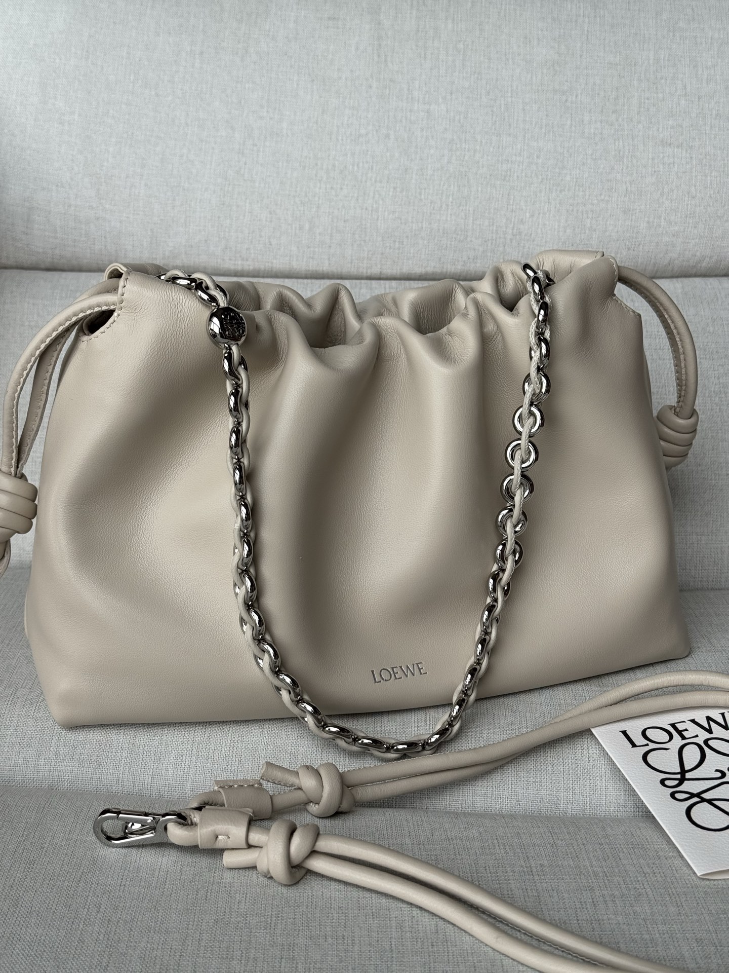 NO:812468,Special grade 1774 (matched with metal chain + 1 long shoulder strap) Soft Nappa Lamb Leather Flamenco Purse Clutch Large size 30-10.5-20 Soft White Flamenco Purse Handbag features a pleated design and key details such as the signature knot on the side. The style is fashionable and versatile and can be carried as a clutch, worn on the shoulder with a donut chain, or worn cross-body with a leather shoulder strap. This version is made of soft Nappa sheep leather. Can be worn on the shoulder, crossbody or handheld Detachable and adjustable leather shoulder strap Detachable donut chain decorated with Anagram engraved pebbles Discreet magnetic closure Suede lining LOEWE hot stamping or silver, premium Loewe, loewe, loewe, handbag, sheepskin19860909特级 1774 上配套金屬鏈條+1條長肩帶） 柔软纳帕羊皮革 Flamenco Purse 手拿包 大號30-10.5-20 柔白 Flamenco Purse 手袋采用褶皱设计,侧面搭配标志性绳结等关键细节.款式时尚百搭,可作为手拿包携带,亦可搭配甜甜圈链条肩背,或搭配皮革肩带斜挎.此版本采用柔软纳帕羊皮革制成. 可肩背、斜挎或手提 可拆卸可调节皮革肩带 可拆卸甜甜圈链条饰有Anagram 镌刻卵石纹 低调的磁扣开合 绒面革衬里 LOEWE烫金或烫银,特级罗意威,loewe,loewe,handbag,sheepskin,Bag