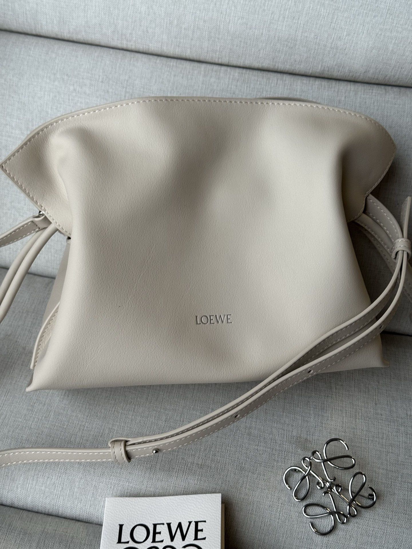 NO:812463,Special grade New version of hot stamping logo Soft white The bag comes with a long shoulder strap Mini nappa cow leather Flamenco clutch Model 11050S 23.9-9-18cm The Flamenco clutch released in the 1870s is tightened with a drawstring and tied with the iconic coiled knot. This mini version is made of nappa cow leather. Can be carried on the shoulder, cross-body or handheld Detachable and adjustable shoulder strap  Low-profile magnetic closure Gold suede lining LOEWE hot stamping or silver, premium Loewe, loewe, loewe, handbag, cowhide19860909特级 新版烫金logo 柔白 包包自配长肩带 迷你纳帕牛皮革 Flamenco 手拿包 型号11050S 23.9-9-18cm 十九世纪七十年代发布的 Flamenco 手拿包,采用拉绳收紧,并打上标志性的盘绕结.此迷你版本采用纳帕牛皮革制成. 可肩背、斜挎或手提 可拆卸可调整肩带 低调的磁扣开合 金色绒面革衬里 LOEWE 烫金或烫银,特级罗意威,loewe,loewe,handbag,cowhide,Bag