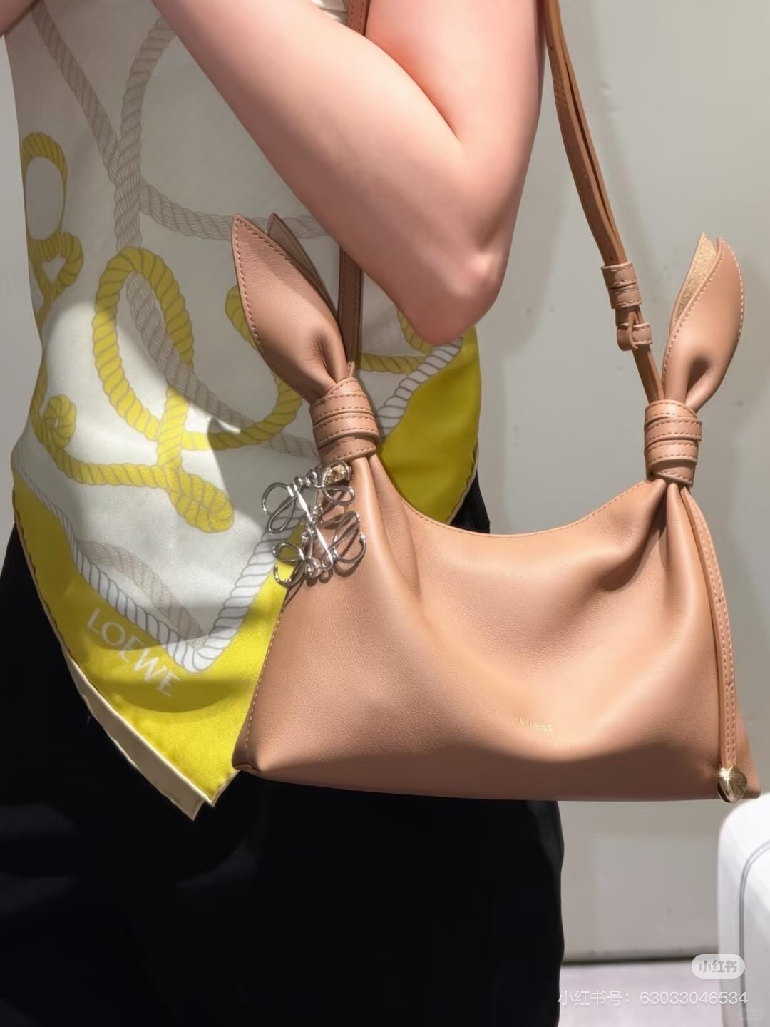 NO:919605,LOEWE Scarf Handbag ~ Rabbit Ear Bag, high-end. Who can resist this LOEWE Scarf handbag with long ears!  Soft cowhide + smart rabbit ear knots, gentle and playful, completely aesthetically pleasing!  Size reference: medium size 34*8.5*21cm, large capacity, can hold mobile phones, umbrellas, powder, keys and other daily goodies, suitable for commuting and going out on the street. Mini size 24.5*6*14.5cm, exquisite and compact, easy to travel with lightness. Materials and details: Made of fine grained cowhide, soft and crisp to the touch, and the body has a superb natural drape.  The rabbit ear knots on both sides are the soul design, the adjustable shoulder straps + the iconic ebble metal pendant at the bottom, the details are exquisite to the core, the black gold/white gold/brown gold color combinations are noble and versatile. Color & Style: Black is cool and capable, full of workplace aura, stain-resistant and classic. White is gentle and clean, perfect for matching with skirts in spring and summer, and full of age reduction.  Mocha brown is retro and gentle, an artifact of autumn and winter atmosphere, versatile and not picky, loewe, skirts, cowhide, umbrellas19860909LOEWE Scarf 手袋～兔子耳朵包,高级感 谁能拒绝这只长耳朵的LOEWE Scarf手袋啊！ 软乎乎的牛皮+灵动兔耳结,温柔又俏皮,完全长在审美点上！ 尺寸参考 中号34*8.5*21cm,容量较大,能装下手机、雨伞、粉饼、钥匙等日常好物,通勤出街都合适 迷你24.5*6*14.5cm,精致小巧,轻装上阵 材质与细节 采用细腻粒面牛皮,触感柔软又挺括,包身自然垂坠感超绝. 两侧兔耳结是灵魂设计,可调节肩带+底部标志性ebble金属坠饰,细节精致到骨子里,黑金/白金/棕金配色都显贵又百搭. 配色&风格 黑色酷飒干练,职场气场全开,耐脏又经典 白色温柔干净,春夏搭配裙装超仙,减龄感拉满 摩卡棕复古温柔,秋冬氛围感神器,百搭不挑皮,,loewe,skirts,cowhide,umbrellas,Bag