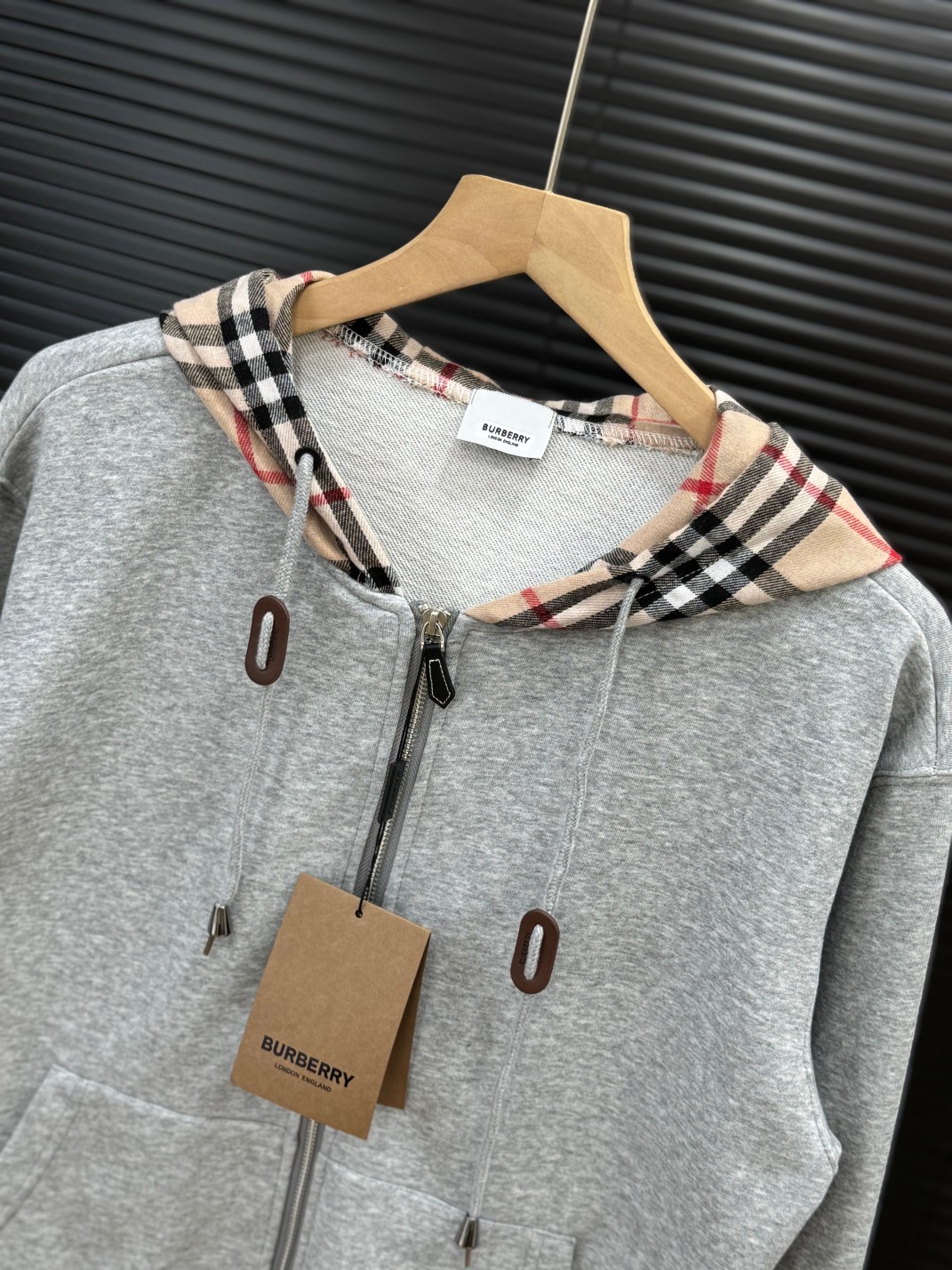 💰165 
Burberry巴宝莉拉链开衫长袖外套 原版巴宝莉条纹布

颜色：黑色/灰色
尺码：M L XL
尺码:  图九

高品质！高版本！帽子经典的格子拼接，人手必备款！辨识度很高，面料采用原版进口纯棉毛圈面料，高克高重，上身舒适度高，亲肤性好，

每个辅料均为定制 成本极高！定制开模品牌Logo五金拉链，原版包装发货，包装，吊牌领标，水洗麦，齐全！