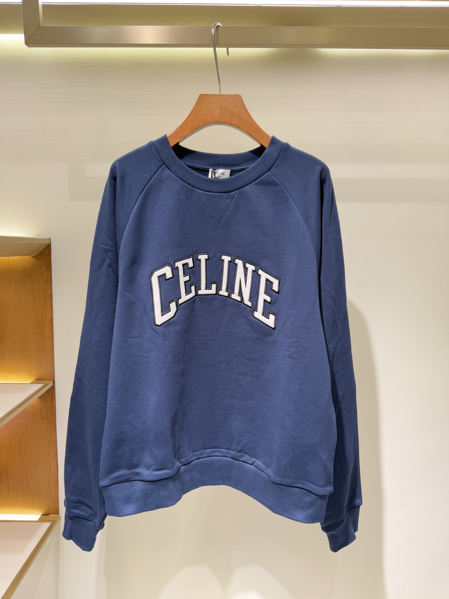 NO:550566,Celine Celine patch embroidery logo navy blue round neck sweatshirt CLIN stroke patch round neck sweatshirt Original 38, purchase; pure cotton terry fabric, patch embroidery technology, classic version, round neck rib trim, V-shaped rib design, full set of accessories No. RYOHD670Q.FZD6 Fabric loop cotton fabric with knitted fabric  Pure cotton sweatshirt fabric; the surface uses 26S combed cotton yarn, the yarn is finer and weighs 380g. The fabric has a smooth, smooth appearance and a delicate touch. The inner terry yarn uses 10S thicker cotton yarn, which weighs 380g.  A loose coil structure is formed during weaving, and after raising treatment, a layer of rich and soft velvet is formed inside. This structure, thin on the outside and thick on the inside, combines the exquisite appearance with internal warmth and breathability, and is highly comfortable to wear.   Craft patch embroidery process The patch embroidery process is more complicated, and the size is customized; the fabric cut into a specific shape is fixed on the main body of the garment, and then embroidery thread is used around and inside it to overlock and refine the pattern. Compared with ordinary embroidery, the patch process can create a more three-dimensional and layered decorative effect. The material of the patch forms a color or texture contrast with the main fabric, making the pattern eye-catching, strong and durable, and greatly improving the visual effect of the single product. The classic version is paired with a V-ribbed design  The style adopts a classic raglan version, which is a universal cut that fits well but is not tight. It is easy to match and suitable for most body types. The neckline adopts a round neck ribbed trim, and the ribbed material has excellent elasticity, which can ensure that the neckline will not be easily deformed after frequent wearing and taking off.   The V-shaped rib design is a key detail. Rib weaving in different directions and stitching are used to form a subtle V-shaped structure in the front of the neckline. This is not only a decorative element, but also has the practical function of visually extending the neck line and modifying the face. Size XS S M L 1116567,,celine,celine,hoodie,sweatshirts,alexander wang19860909Celine 赛琳贴布刺绣logo海军蓝圆领卫衣 CLIN描边贴布圆领卫衣 原38,购买；纯棉质毛圈面料、贴布刺绣工艺、经典版型、圆领罗纹饰边、V字罗纹设、全套辅料配备 编号RYOHD670Q.FZD6 面料回圈棉质面料搭配针织面料 纯棉质卫衣面料；表面使用26S的精梳棉纱,纱线较细克重380g,面料的外观光洁、平整且触感细腻.内里毛圈纱使用10S的较粗棉纱克重380g,在编织时形成松散的线圈结构,经起绒处理后,在内部形成一层丰盈柔软的绒毛.这种外细内粗的结构兼具了外观的精致感与内在的保暖透气性,穿着舒适度高. 工艺贴布刺绣工艺 贴布刺绣工艺较为复杂,对版定制尺寸；将切割成特定形状的布料固定在衣身主体上,再在其周围及内部用绣线进行锁边和图案细化.贴布工艺相比普通刺绣,能打造更具立体感和层次感的装饰效果.贴布的材质与主体面料形成色彩或质感的对比,使得图案醒目且牢固耐用,极大地提升了单品的视觉效果. 经典版型搭配V字罗纹设计 款式采用经典插肩版型,即合身但不紧身的通用剪裁,易于搭配且适合大多数体型.领口采用圆领罗纹饰边,罗纹材质弹性优异,能保证领口频繁穿脱后不易变形. V字罗纹设计是一个关键细节,在领口正前方通过不同方向的罗纹编织搭配缝线形成一个微妙的V形结构,这不仅是一个装饰元素,更能起到视觉延伸颈部线条、修饰脸型的实用功能. 尺码XS S M L 1116567,,celine,celine,hoodie,sweatshirts,alexander wang,Men's clothing