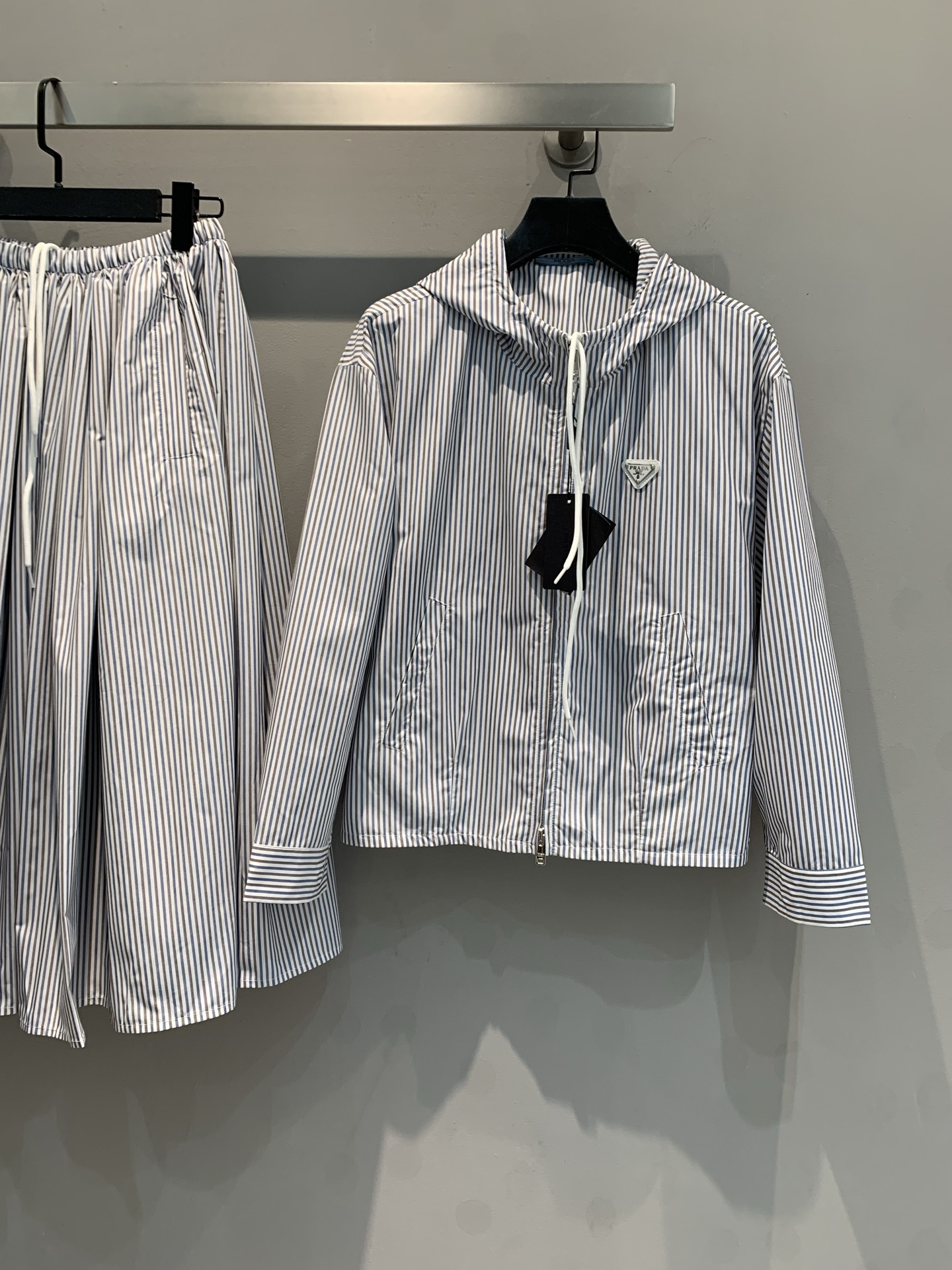 NO:322061,New model shipped 0 Original development Prad*2025 early spring new hooded zipper jacket. Original custom fabric, multi-position bone position pressing process, mold opening logo hardware accessories, simple vertical stripes, visually elongate the body. The hooded zipper design is casual and unique; it is paired with wide-leg skirts of the same element, easily adapted to multiple occasions, helping you become the focus of the street. Number of codes 36 38 40,,prada, skirts, jackets & coats,hats,alexander wang19860909新款出货啦0 原版开发 Prad*2025早春新款连帽拉链外套.原版定制面料,多处骨位压线工艺,开模logo五金配件,简约竖条纹,视觉上拉长身形.连帽拉链设计休闲又不失个性；搭配同元素阔腿裙,轻松适配多种场合,助你成为街头焦点.码数 36 38 40,,prada,skirts,jackets & coats,hats,alexander wang,Women's clothing